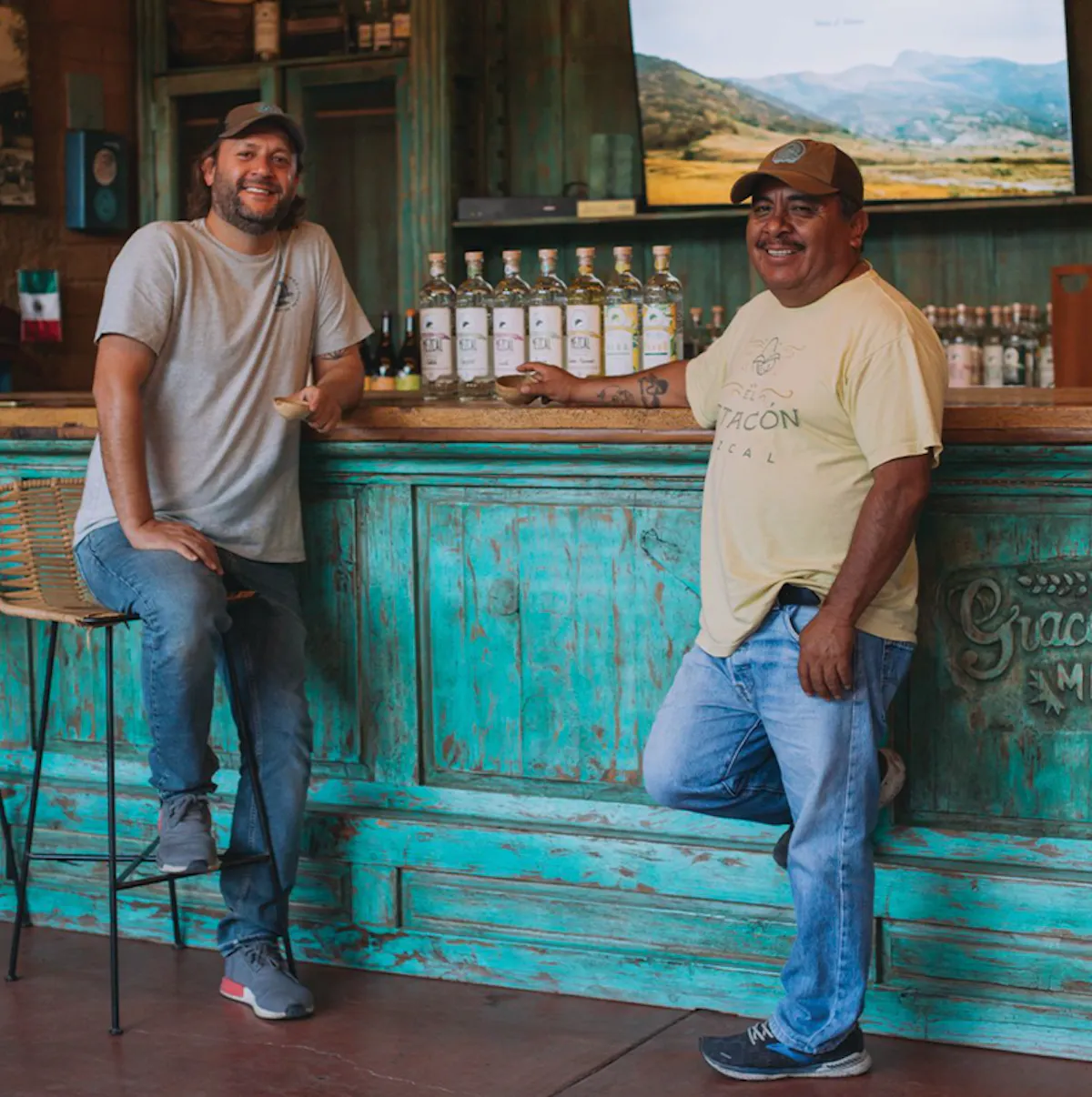 two men standing at a bar