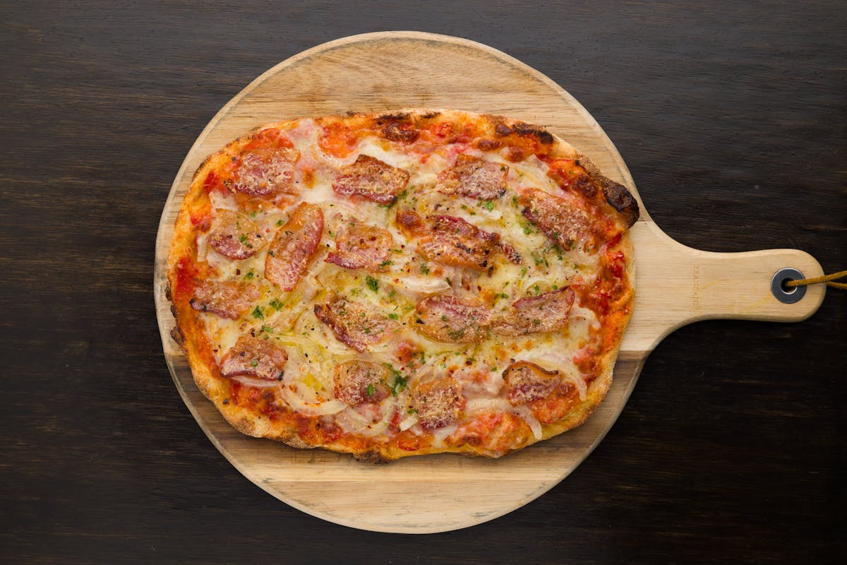 a pizza sitting on top of a wooden cutting board