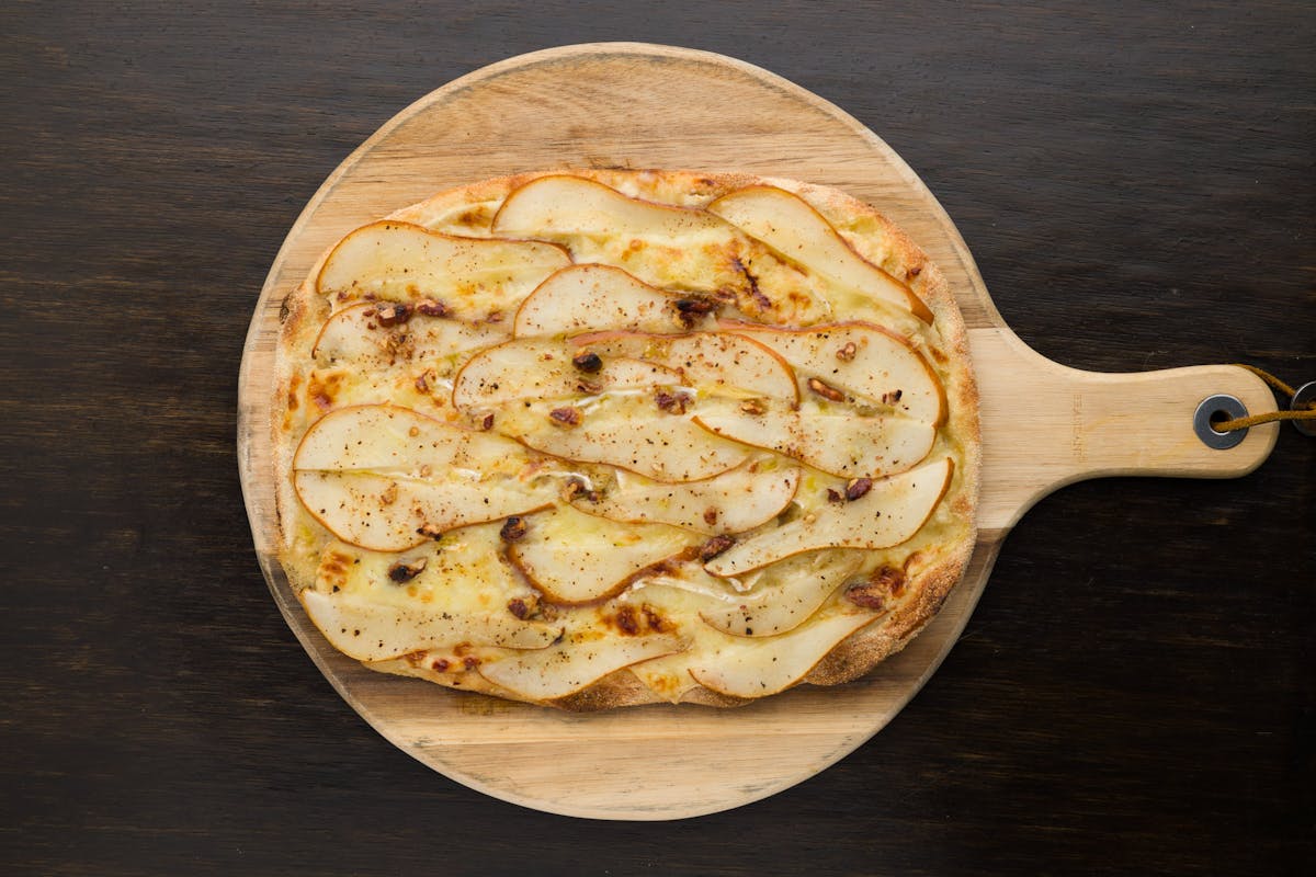 a pizza sitting on top of a wooden table