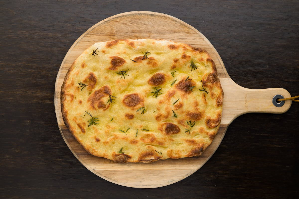 a pizza sitting on top of a wooden cutting board