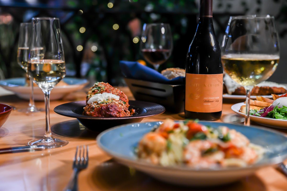 a plate of food and glasses of wine on a table