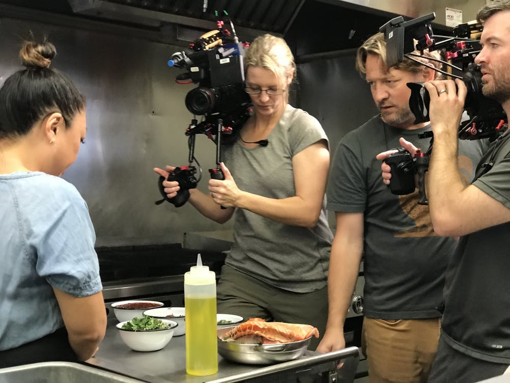 a couple filming a woman talking about food