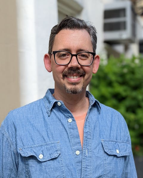 a man wearing glasses and a blue shirt