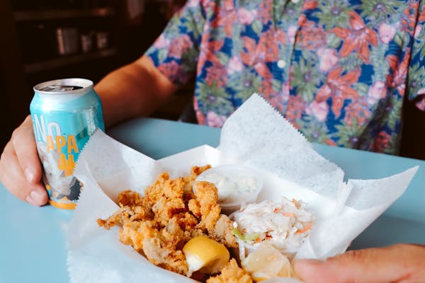 a person holding a piece of food on a table