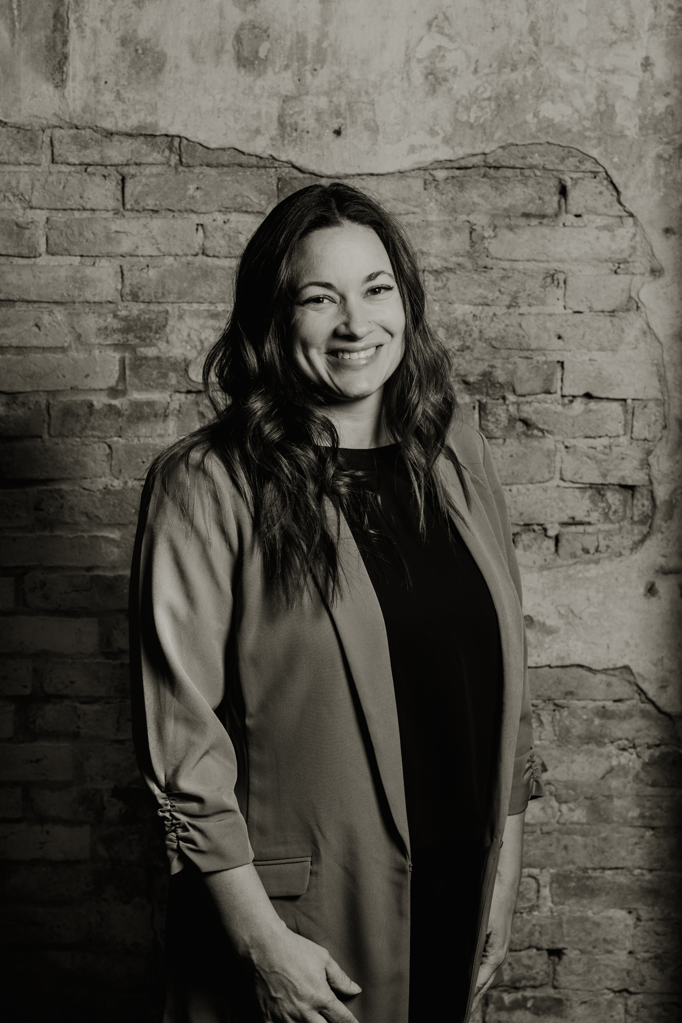 a person standing in front of a brick wall