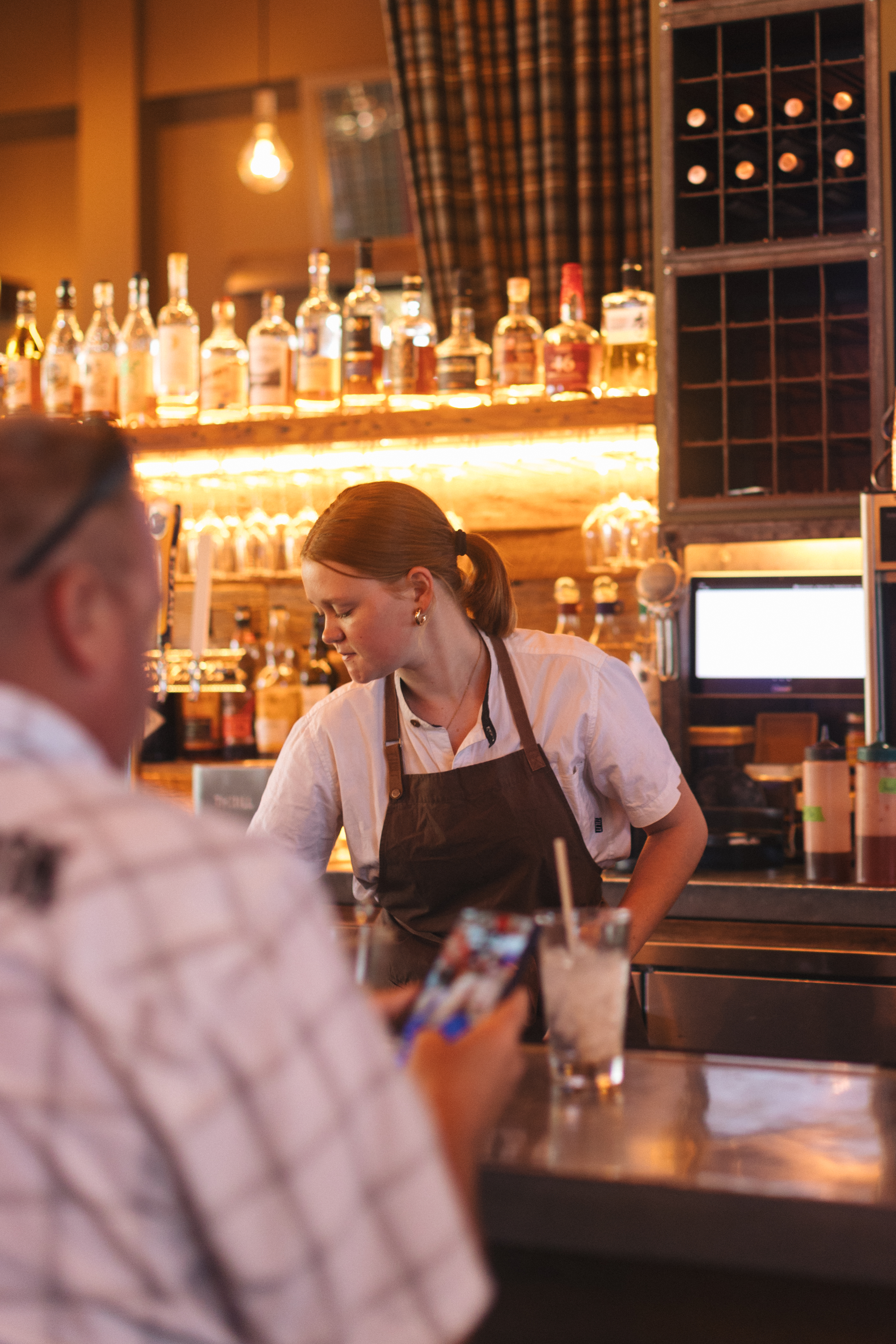 A Firefly Grill bartender chatting with a guest at the bar