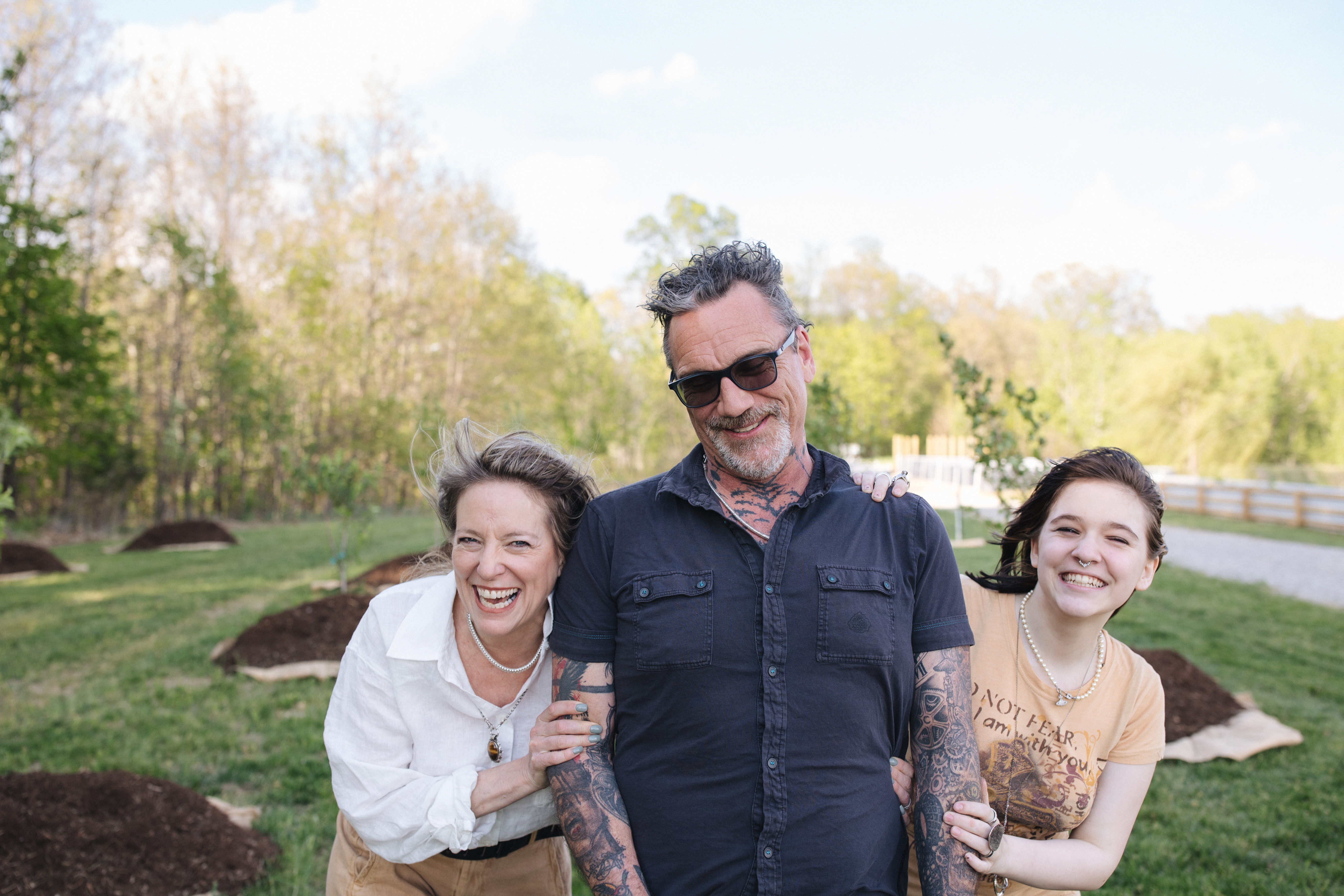The Campbell family standing together in Firefly Farm's recently planted orchard