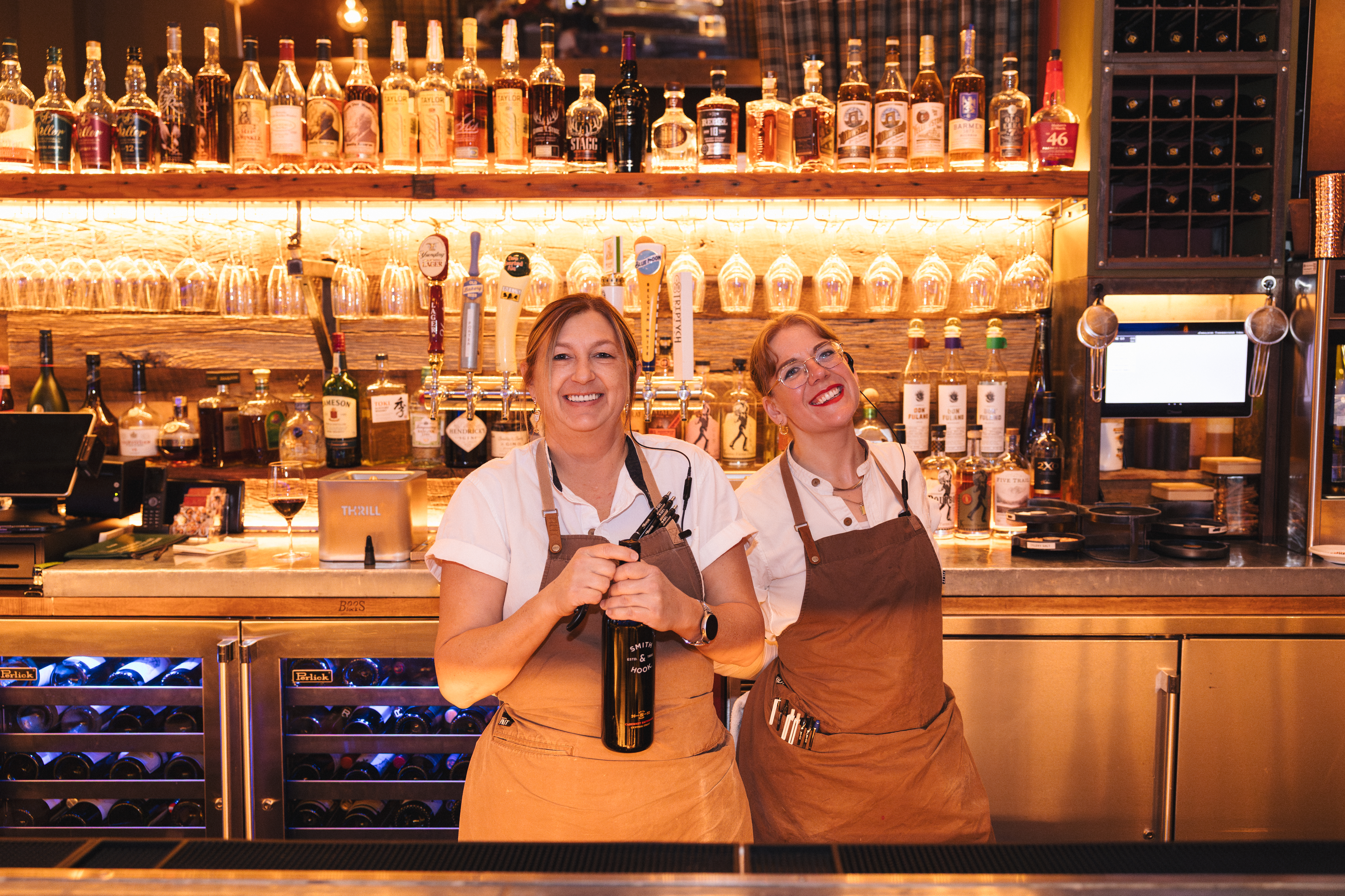 Two Firefly Grill bartenders smiling behind the bar on New Year's Eve