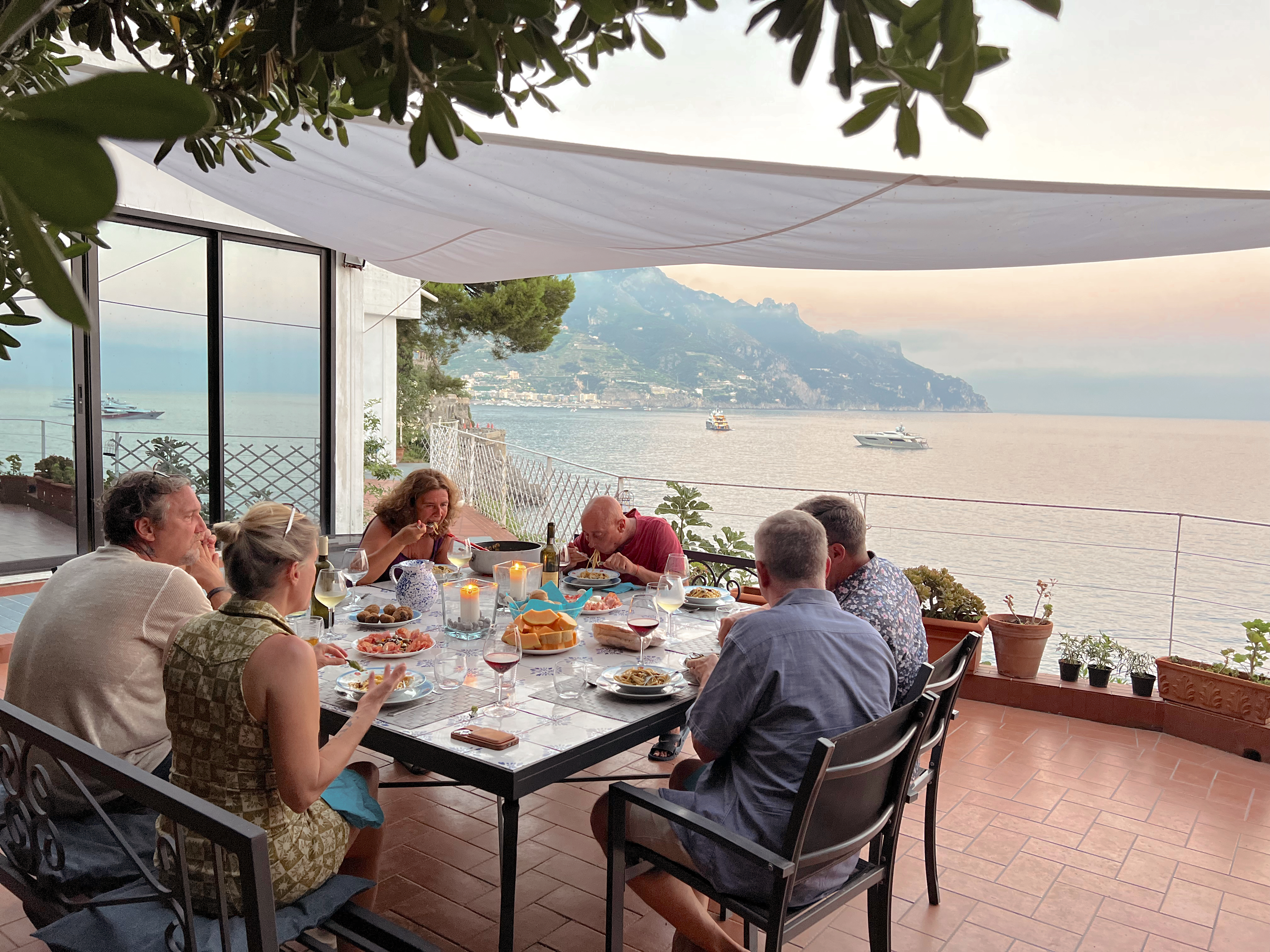 a group of people sitting at a table in front of water
