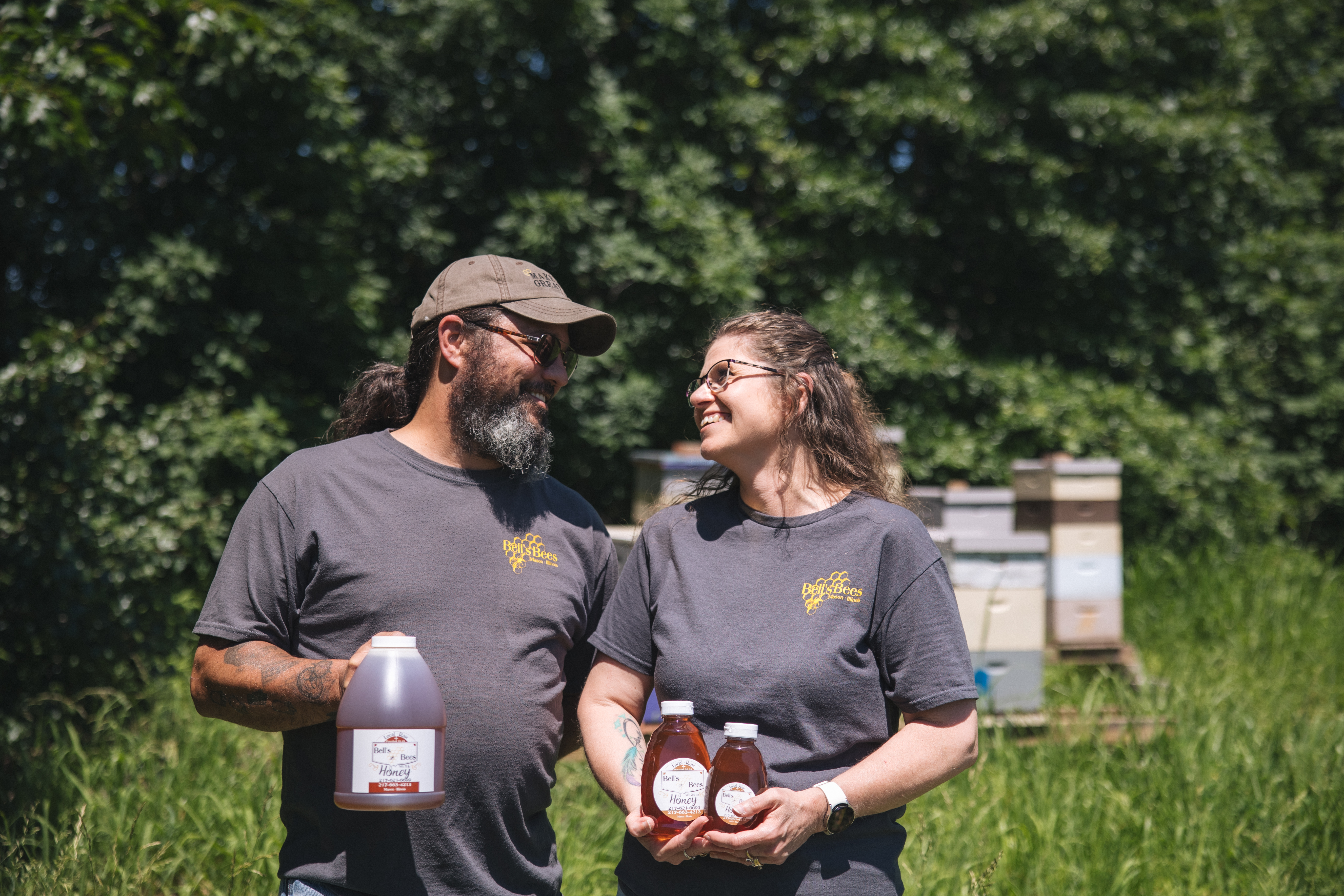 Bell's Bees beekeepers holding jars of their honey