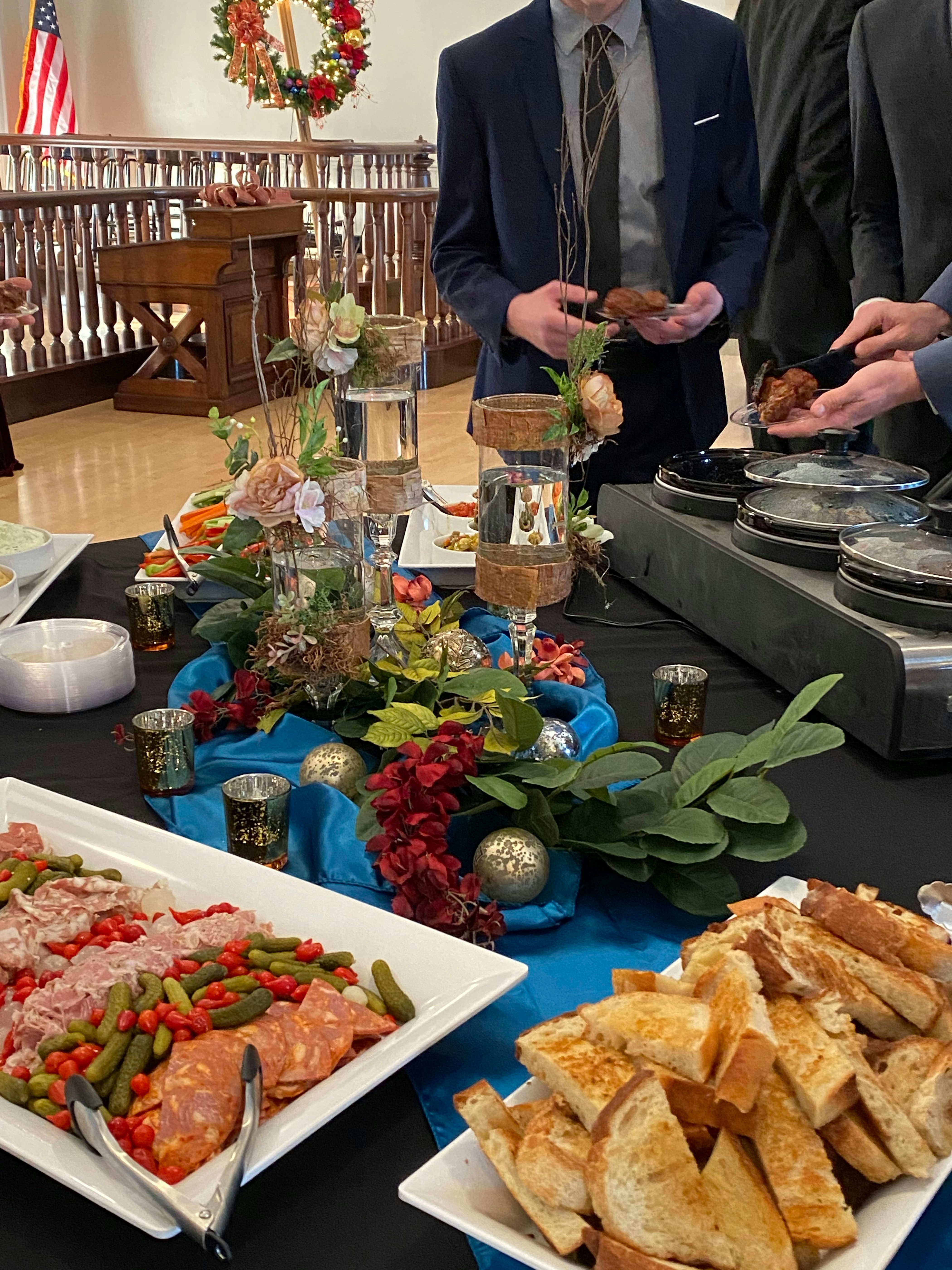 a group of people standing around a table with food