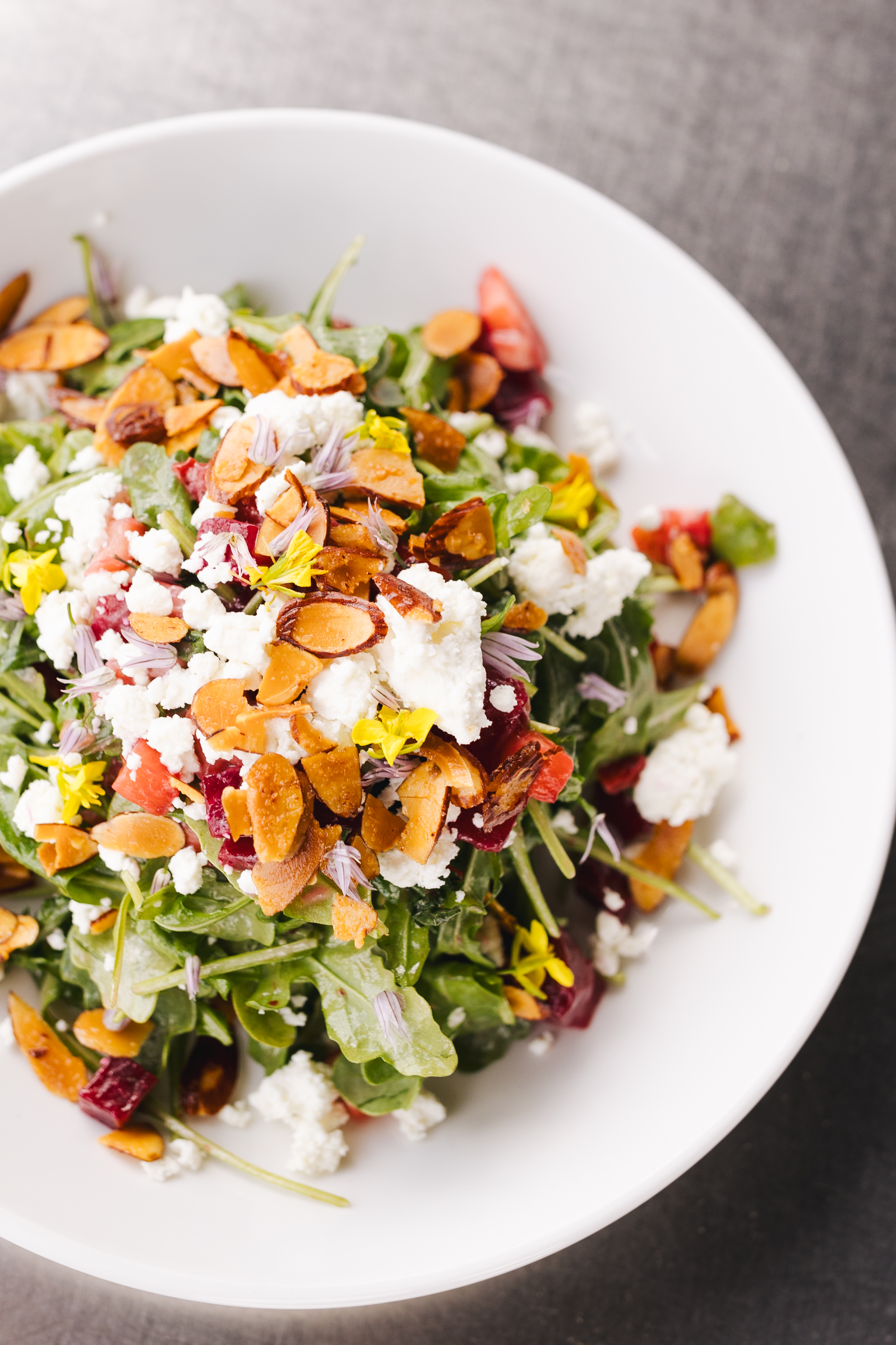 a salad with cheese and nuts on a white plate