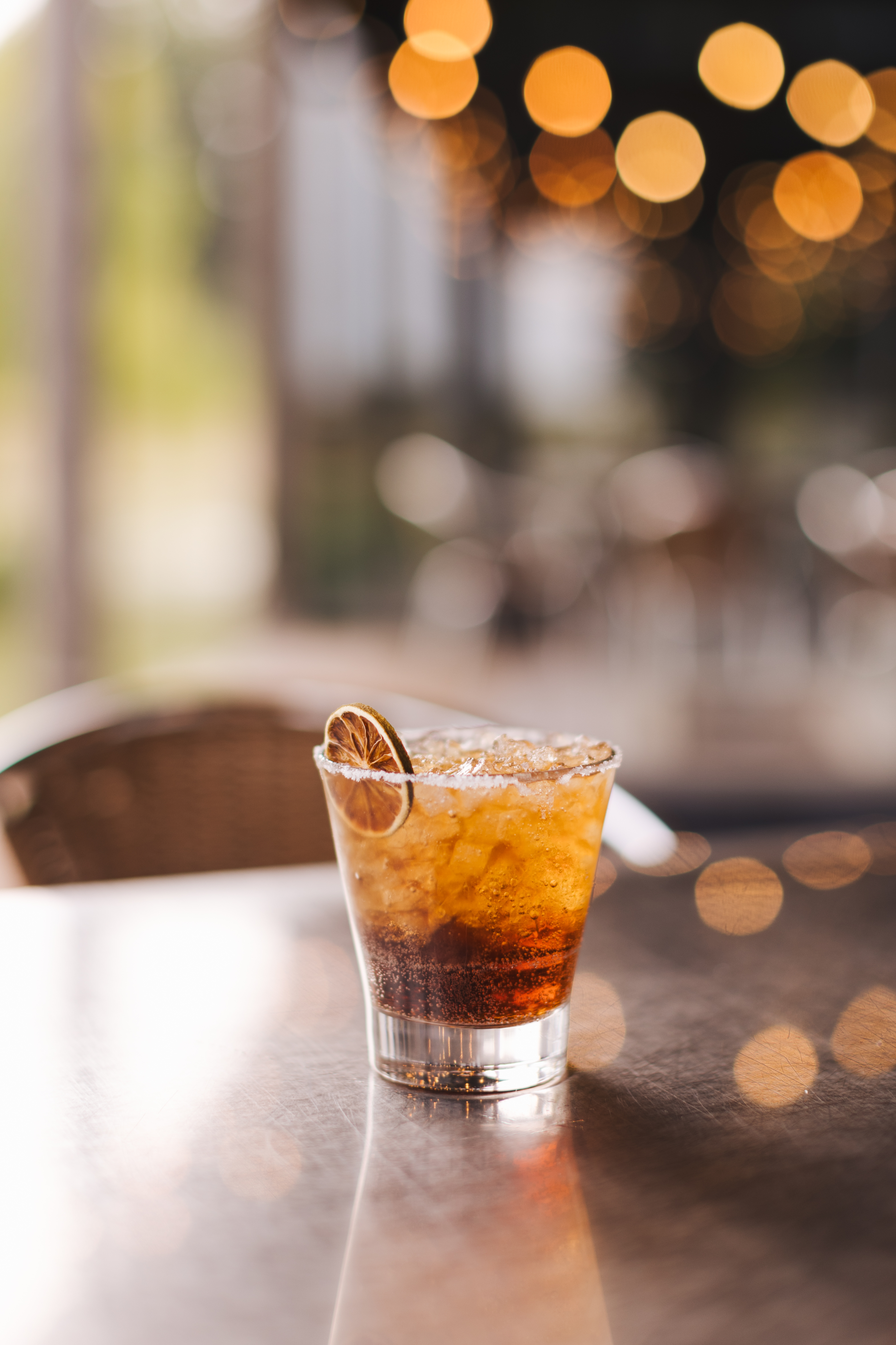 a glass with a drink and a slice of lime on top