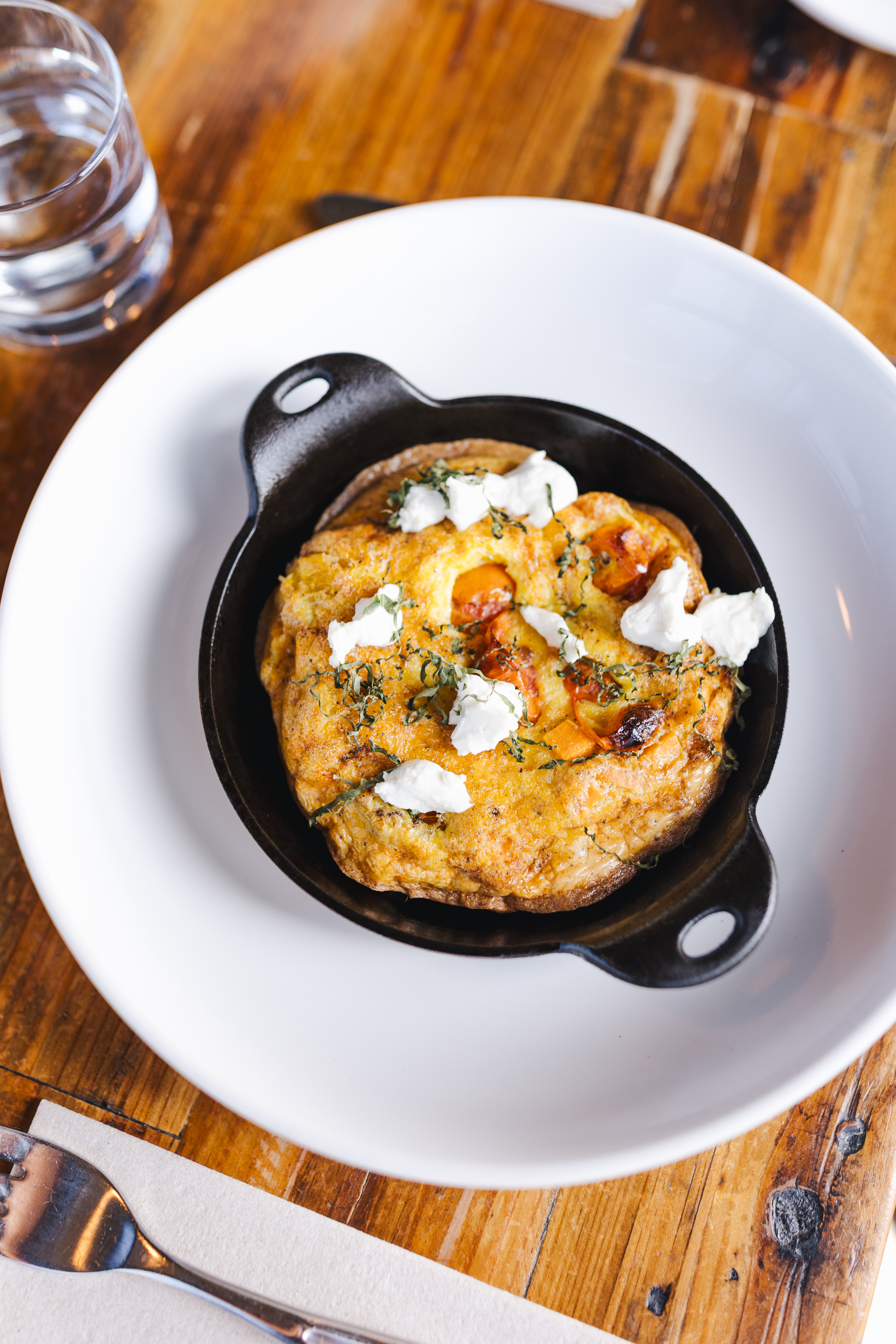 a skillet with cheese and herbs on a white plate