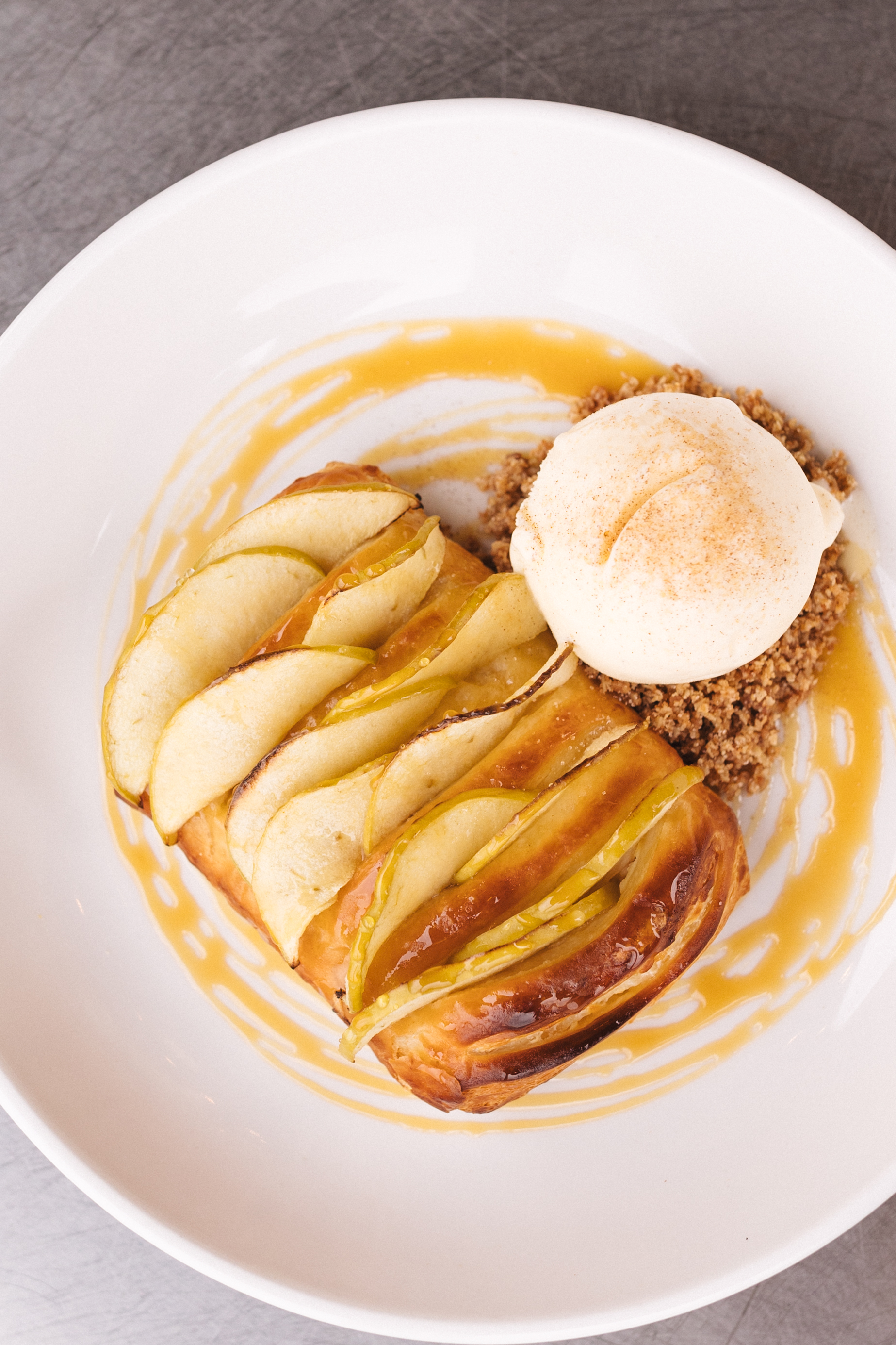 a plate of food with a scoop of ice cream and apples