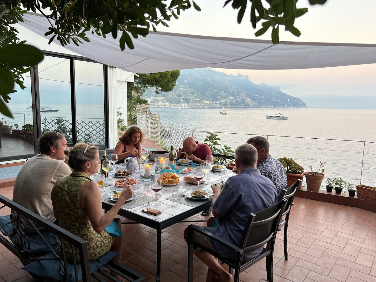 a group of people sitting at a table in front of a lake