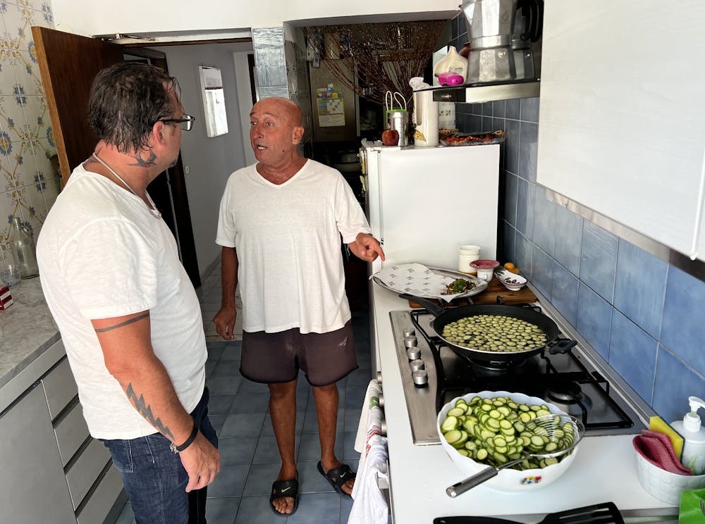 a man and woman preparing food in a kitchen