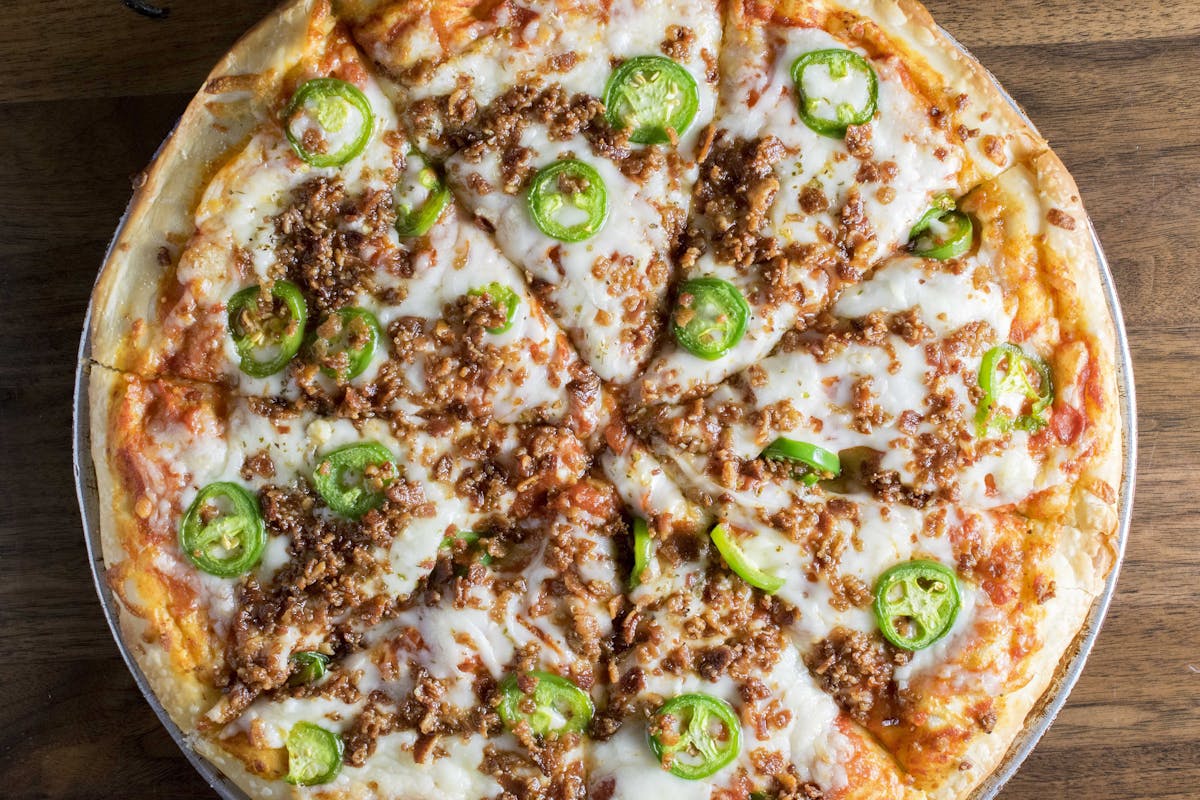 a pizza sitting on top of a wooden table