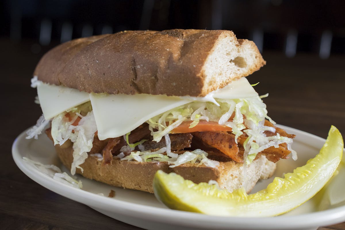 a close up of a sandwich filled with vegetables and meat