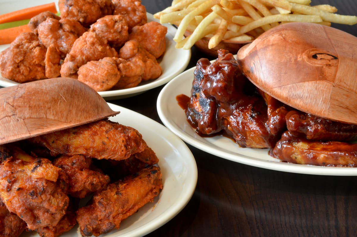 four plates of food sitting on top of a wooden table