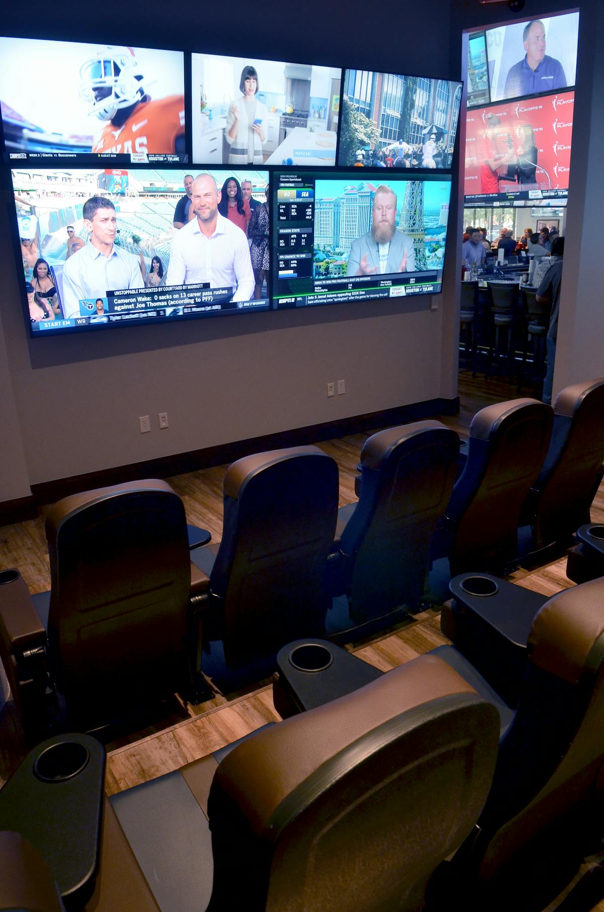 several screens on a cinema-like room with leather seats.