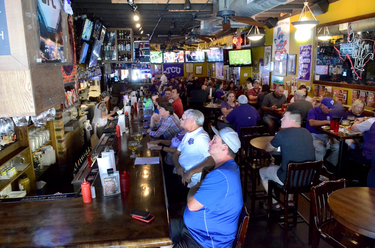 a group of people watching the game on the restaurant's bar