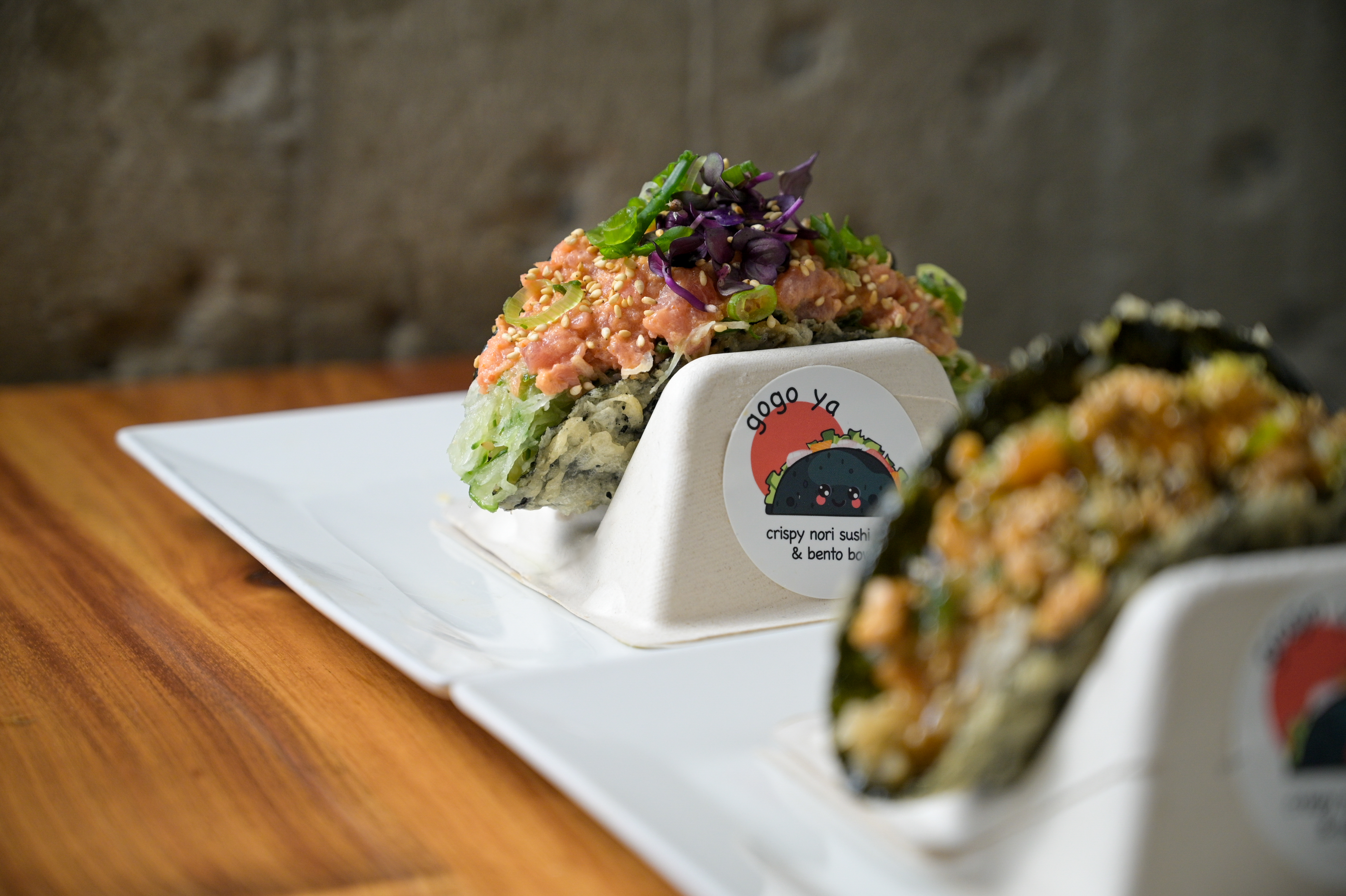 a piece of cake sitting on top of sushi on a table