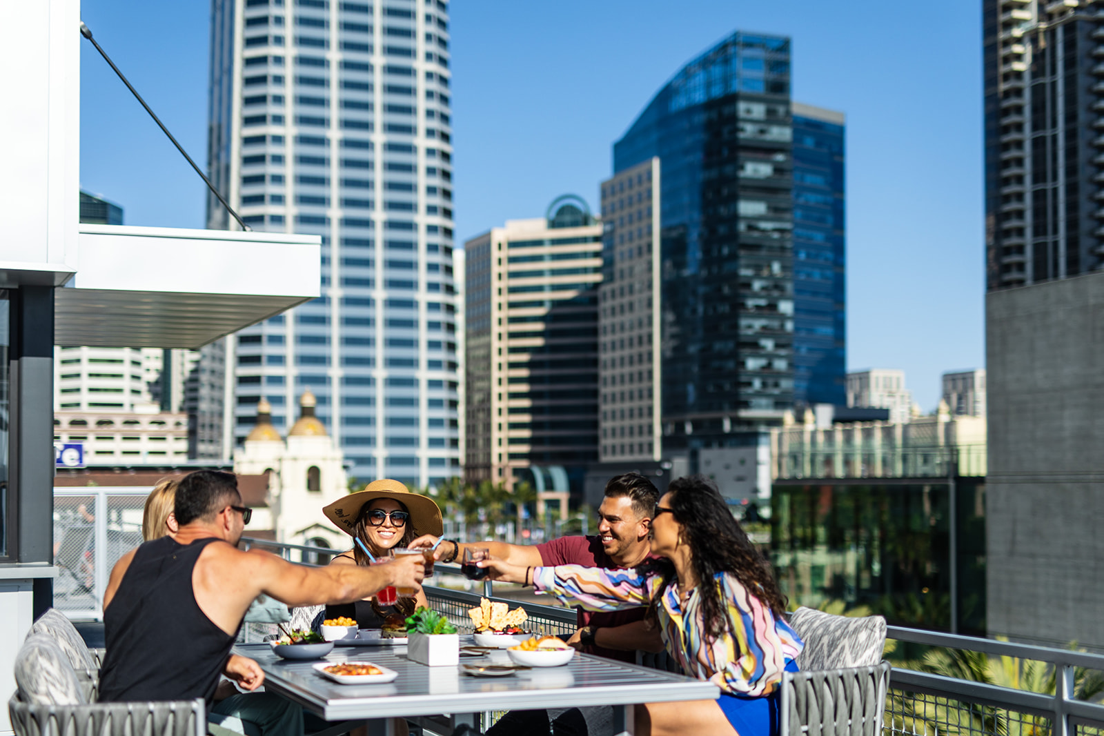 a group of people sitting at a table with a city in the background