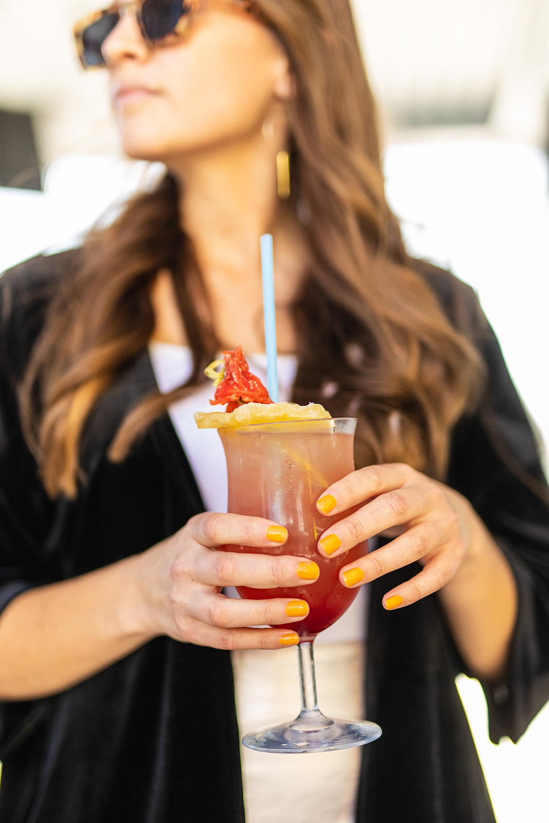 a woman holding a cocktail
