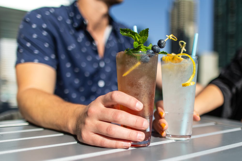 a person holding a glass of beer on a table
