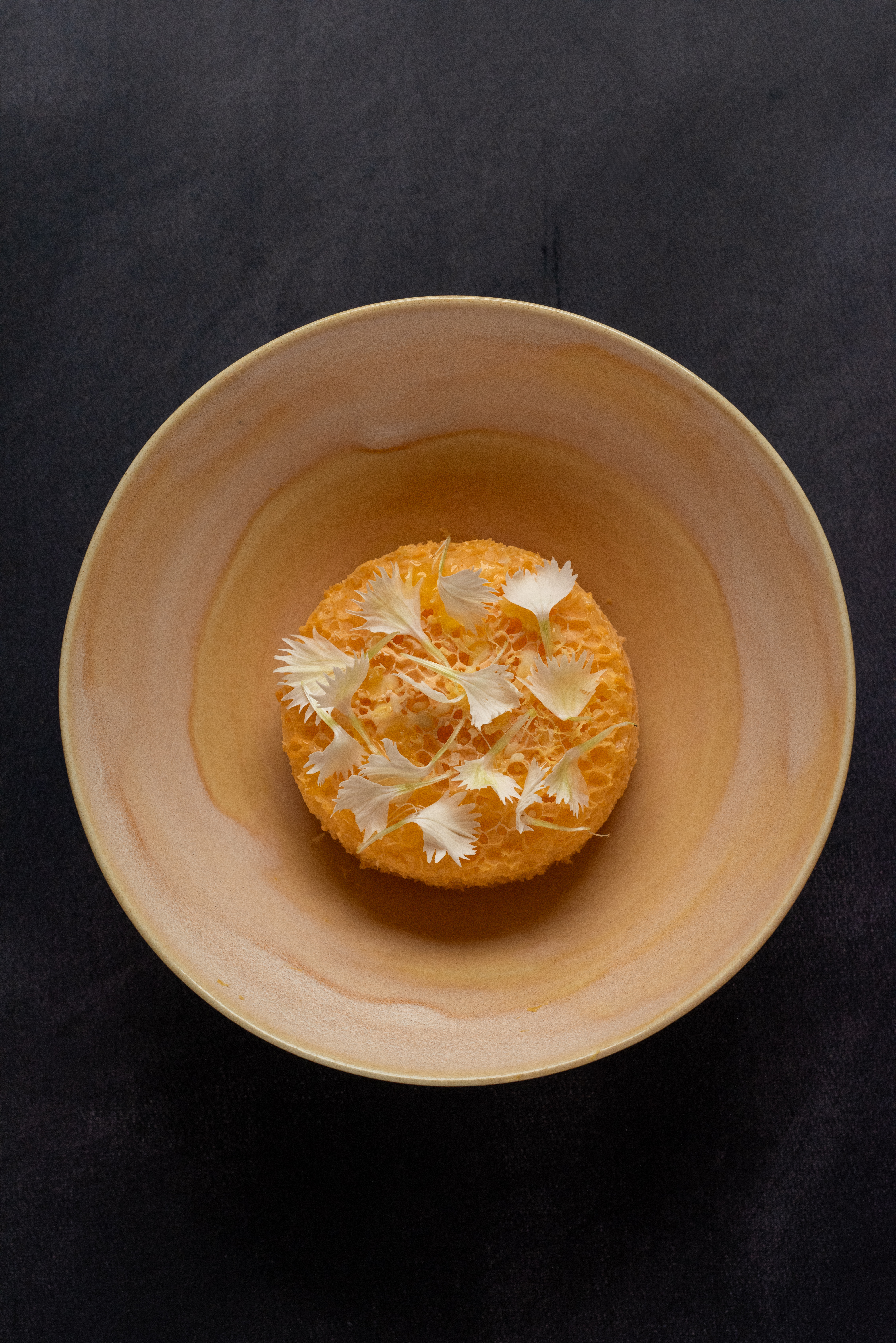 a close up photo of yellow parfait with white flowers
