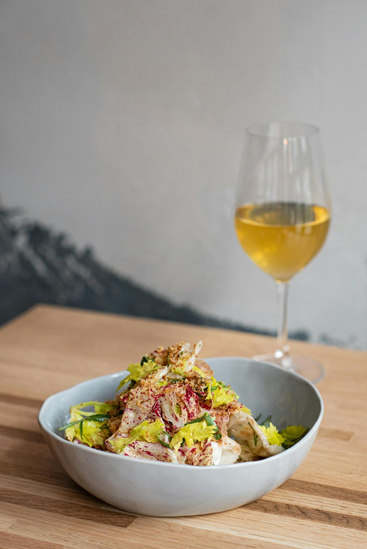 a bowl of food and a glass of wine