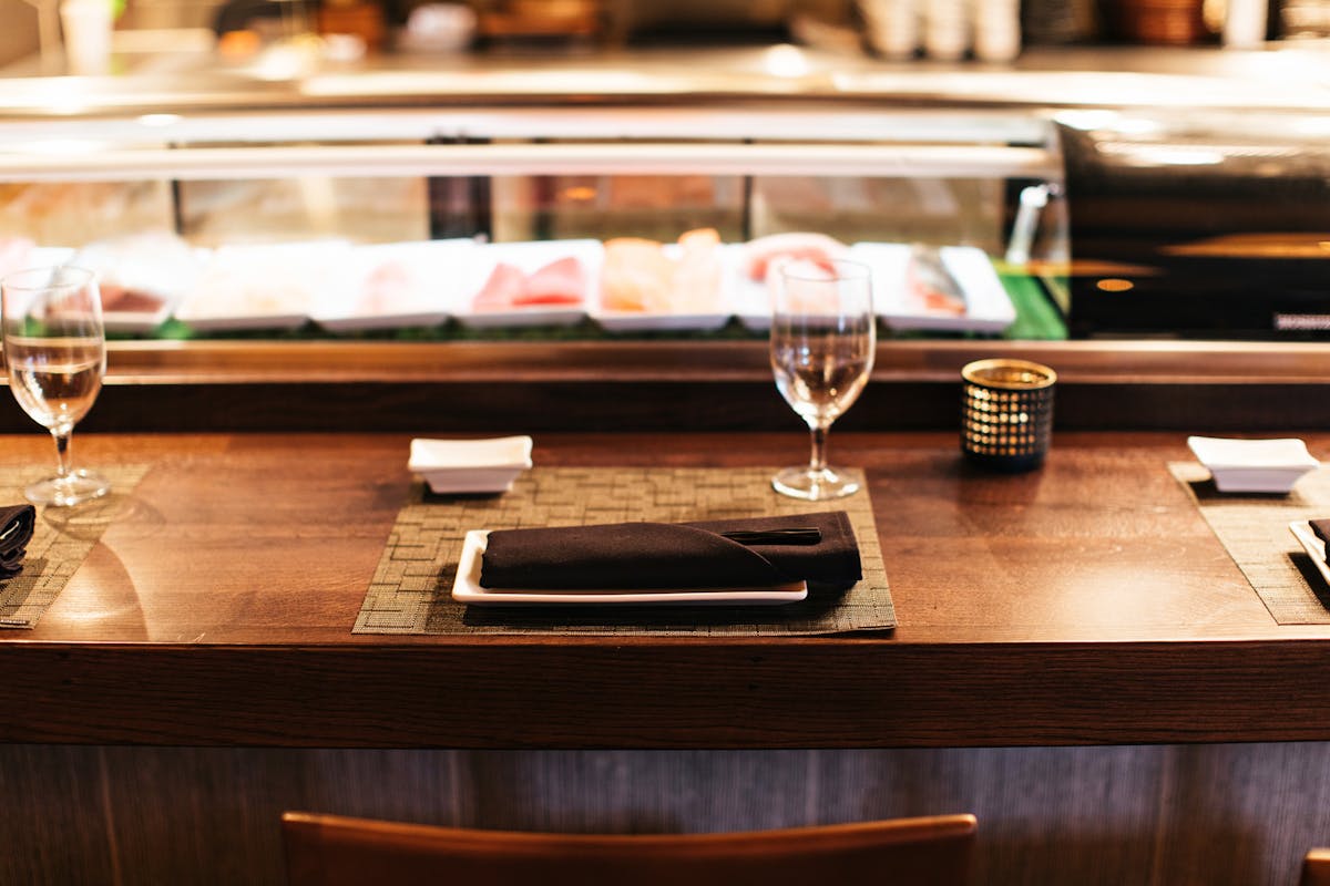 a glass of wine sitting on top of a wooden counter