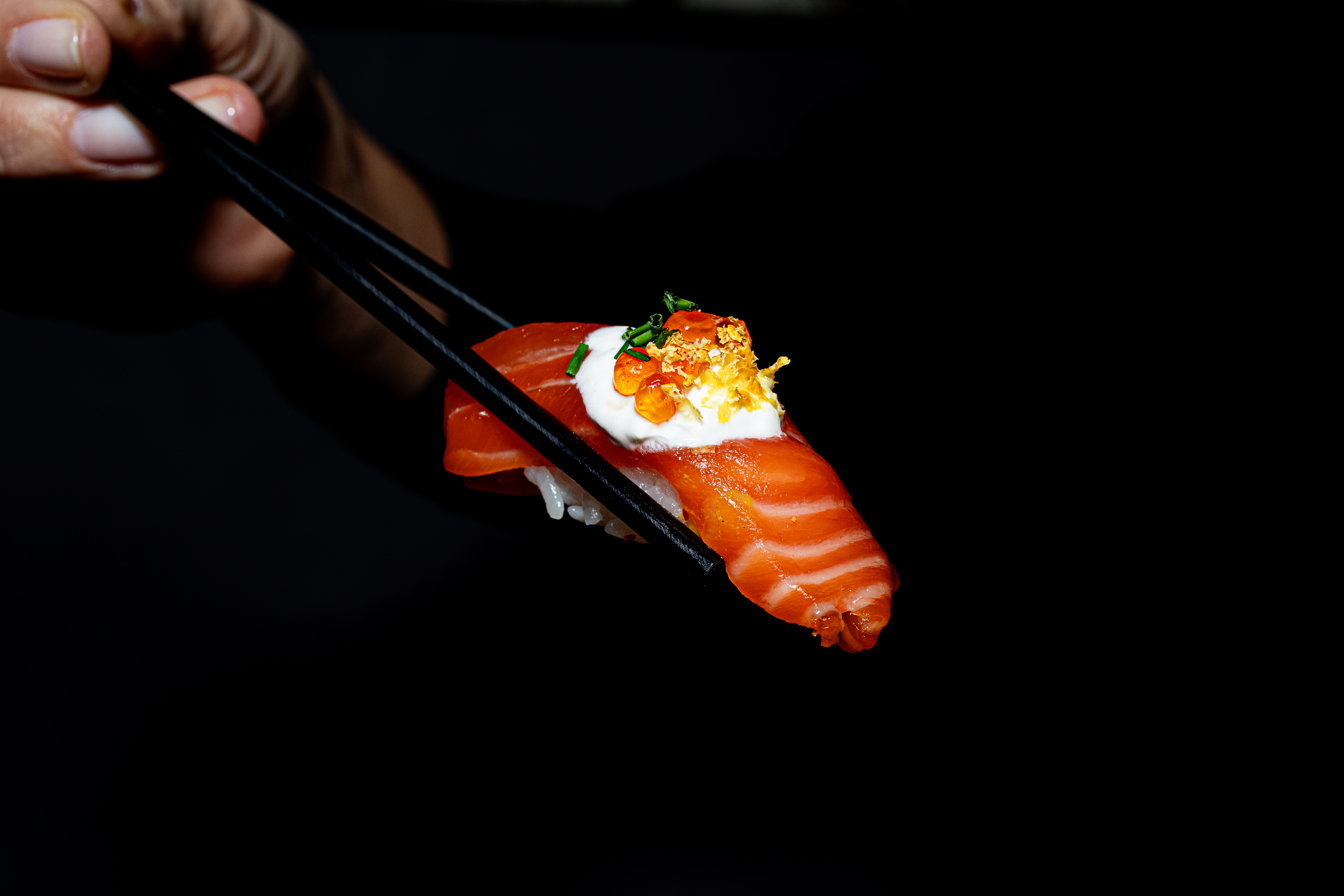 a hand holding a slice of pizza