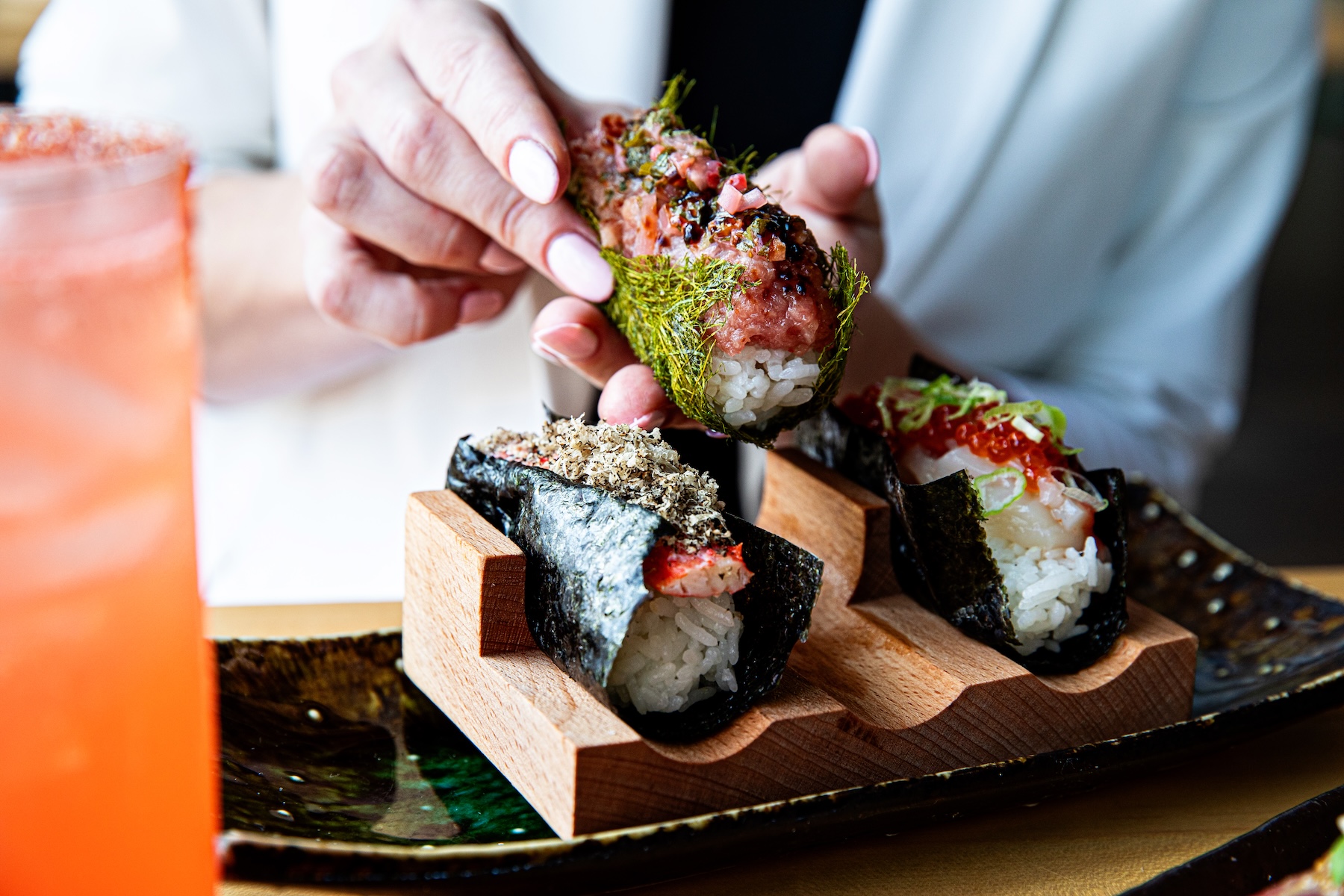 a person holding a sushi roll