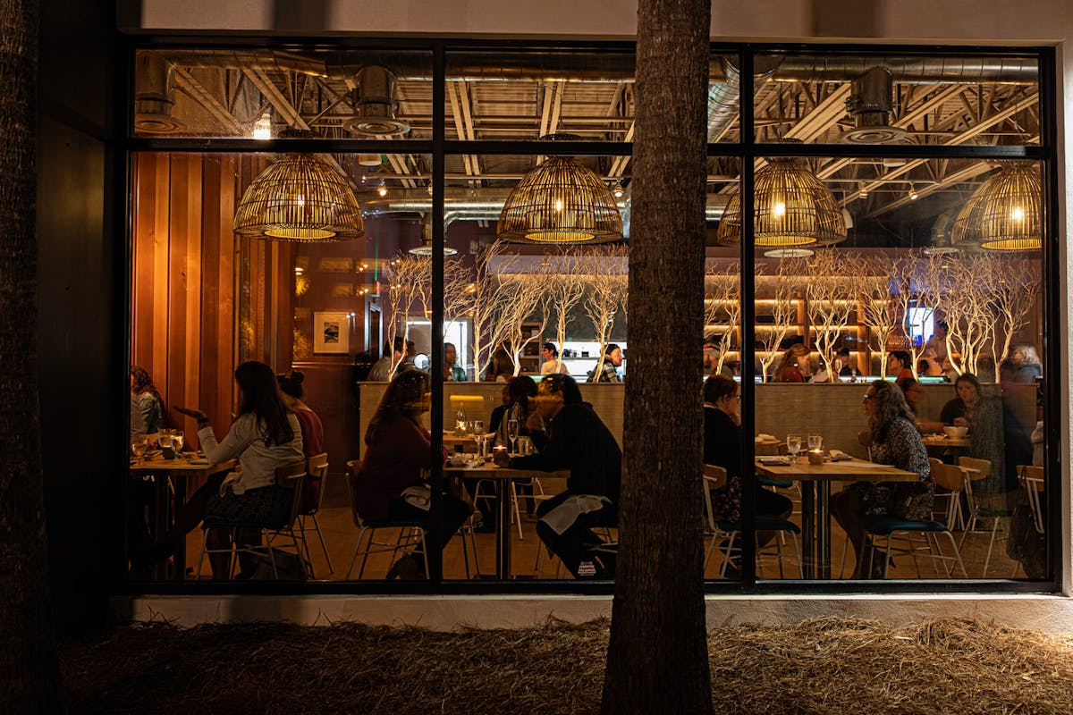 a group of people sitting at a table in front of a building