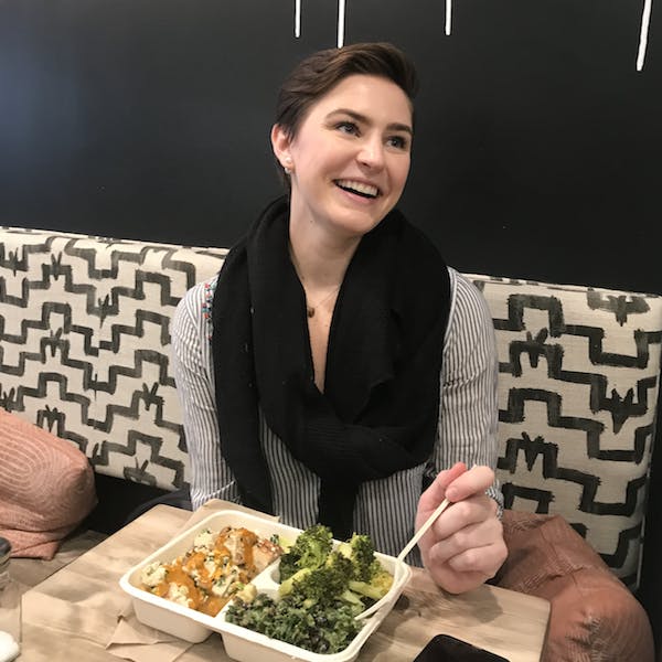 a woman sitting at a table with a plate of food