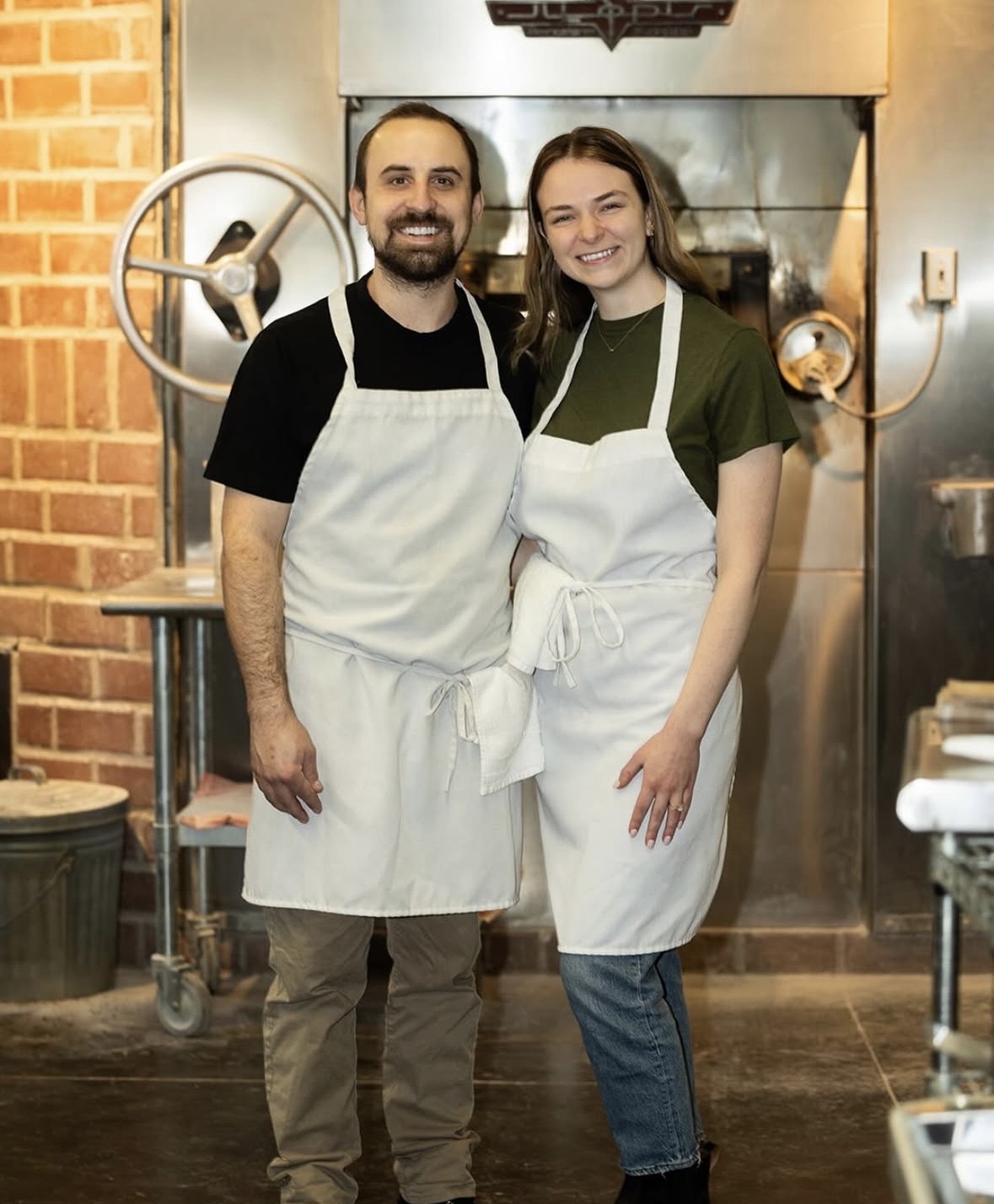 two people standing in aprons