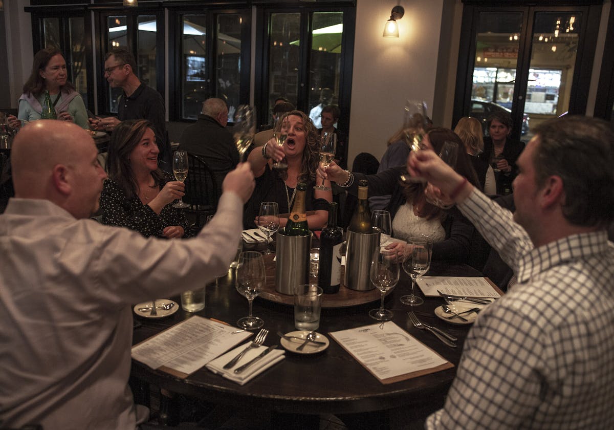 a group of people sitting at a table with wine glasses