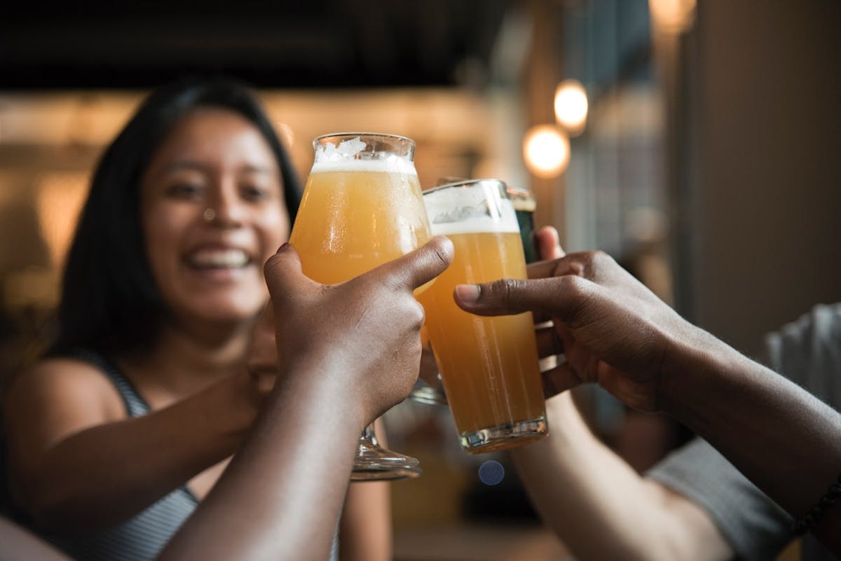 a hand holding a glass of orange juice