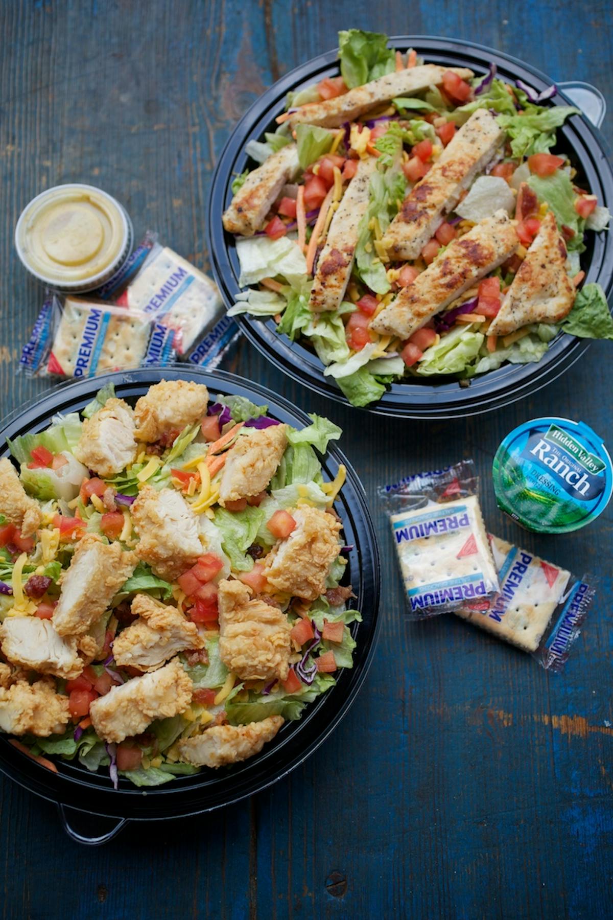 a close up of two types of salads on a table