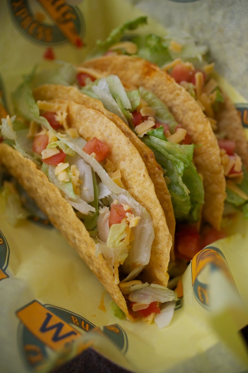 a close up of three tacos on top of a wrapping paper