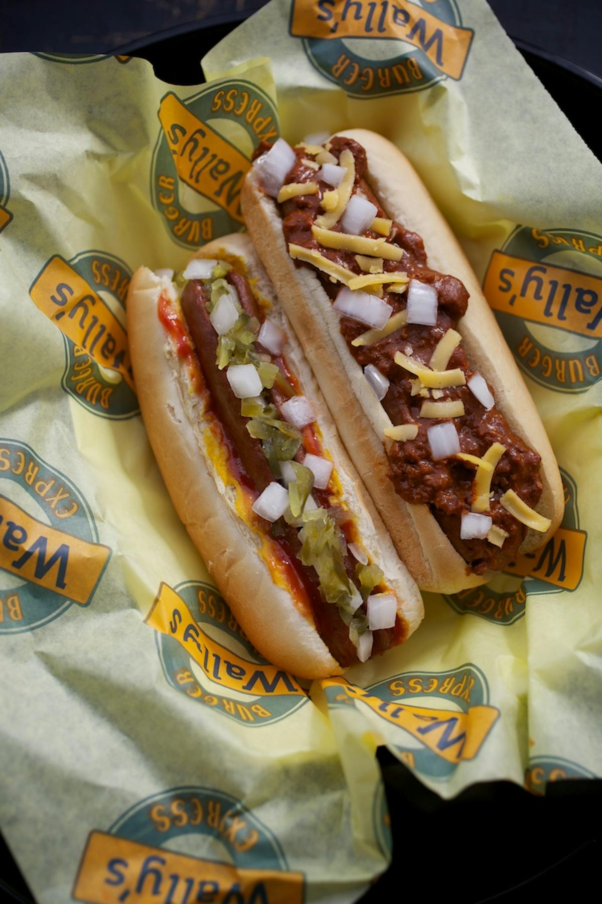 a close up of two hot dogs on top of a wrapping paper