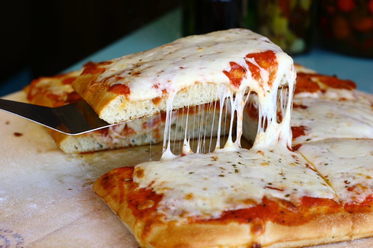 a close up of a slice of pizza on a paper plate