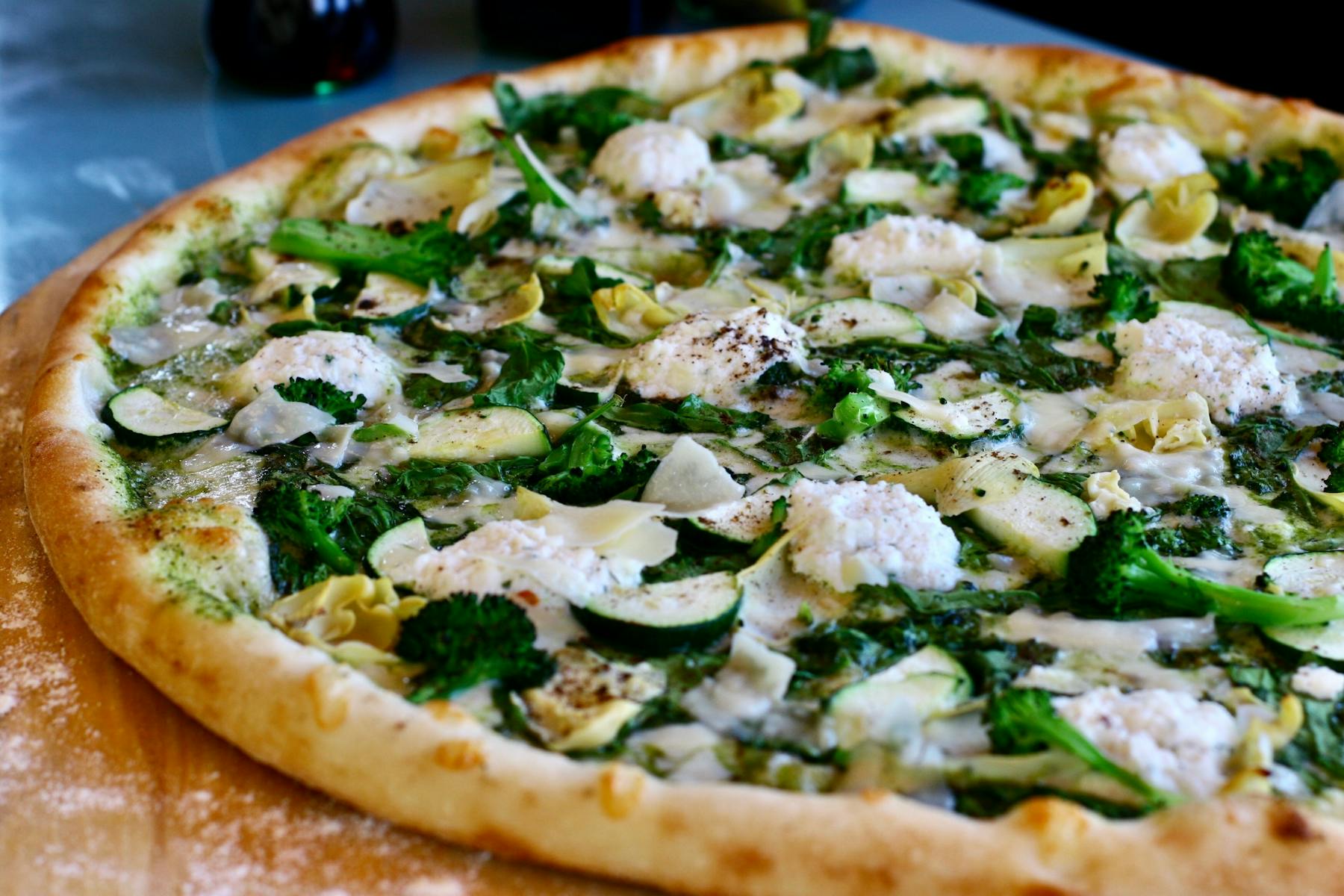 a pizza sitting on top of a wooden cutting board