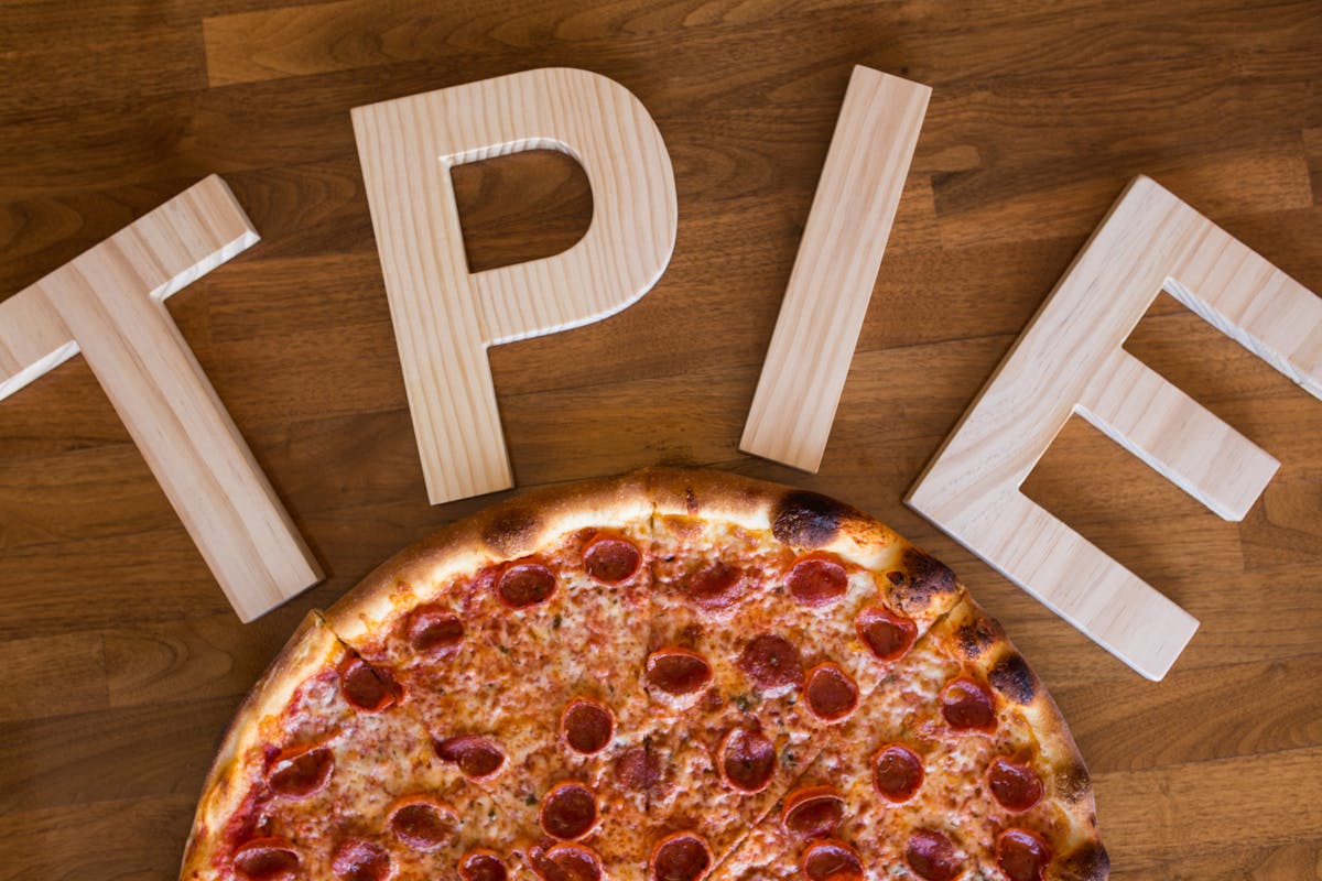 a pizza sitting on top of a wooden table