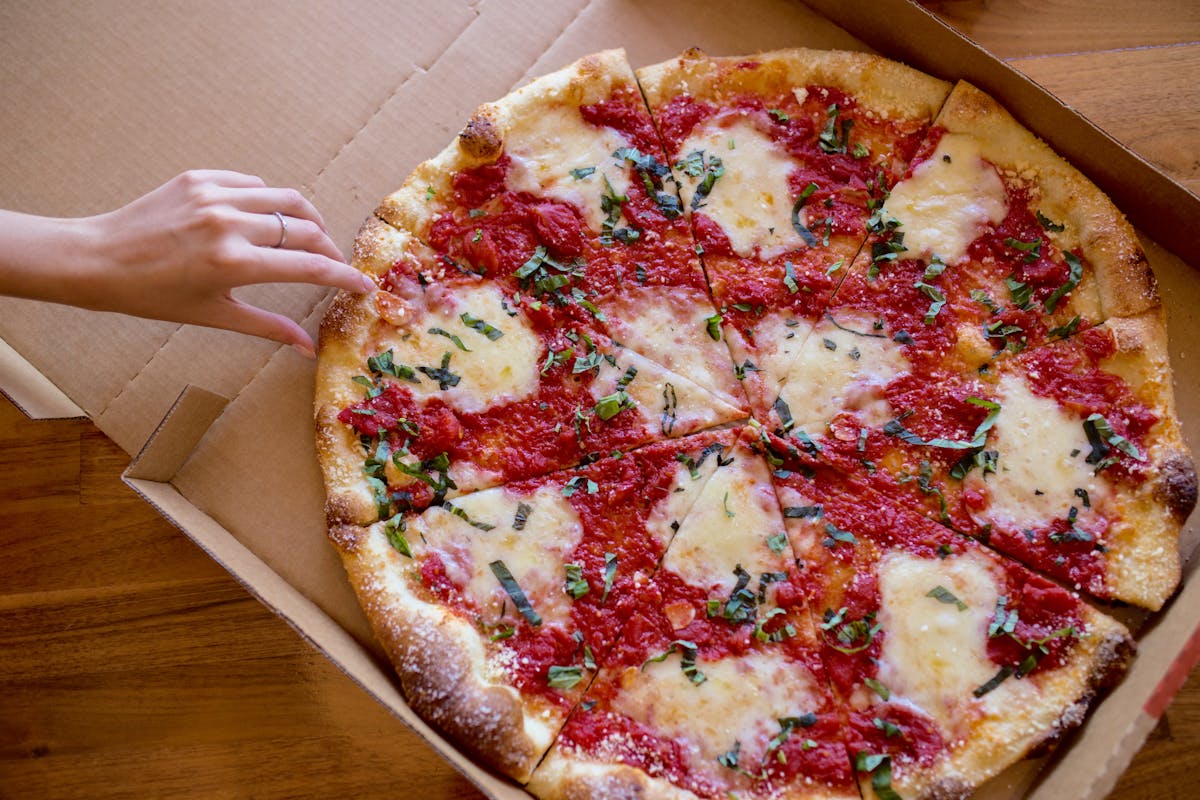 a pizza sitting on top of a wooden cutting board