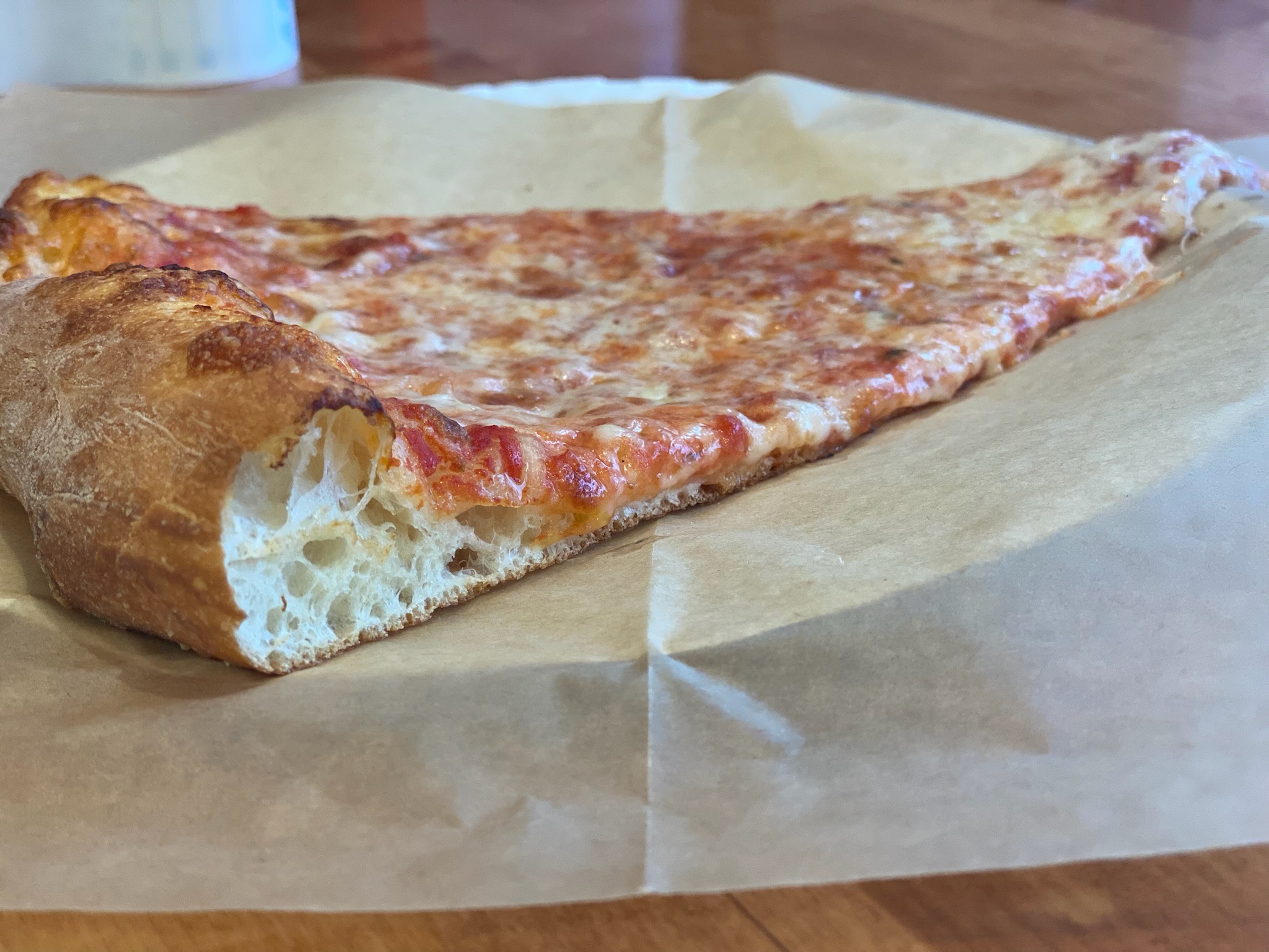 a slice of pizza sitting on top of a wooden table