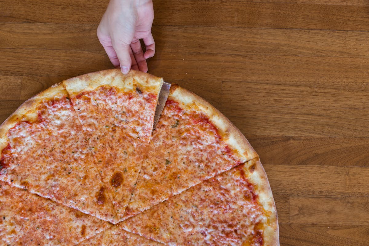 a person holding a slice of pizza