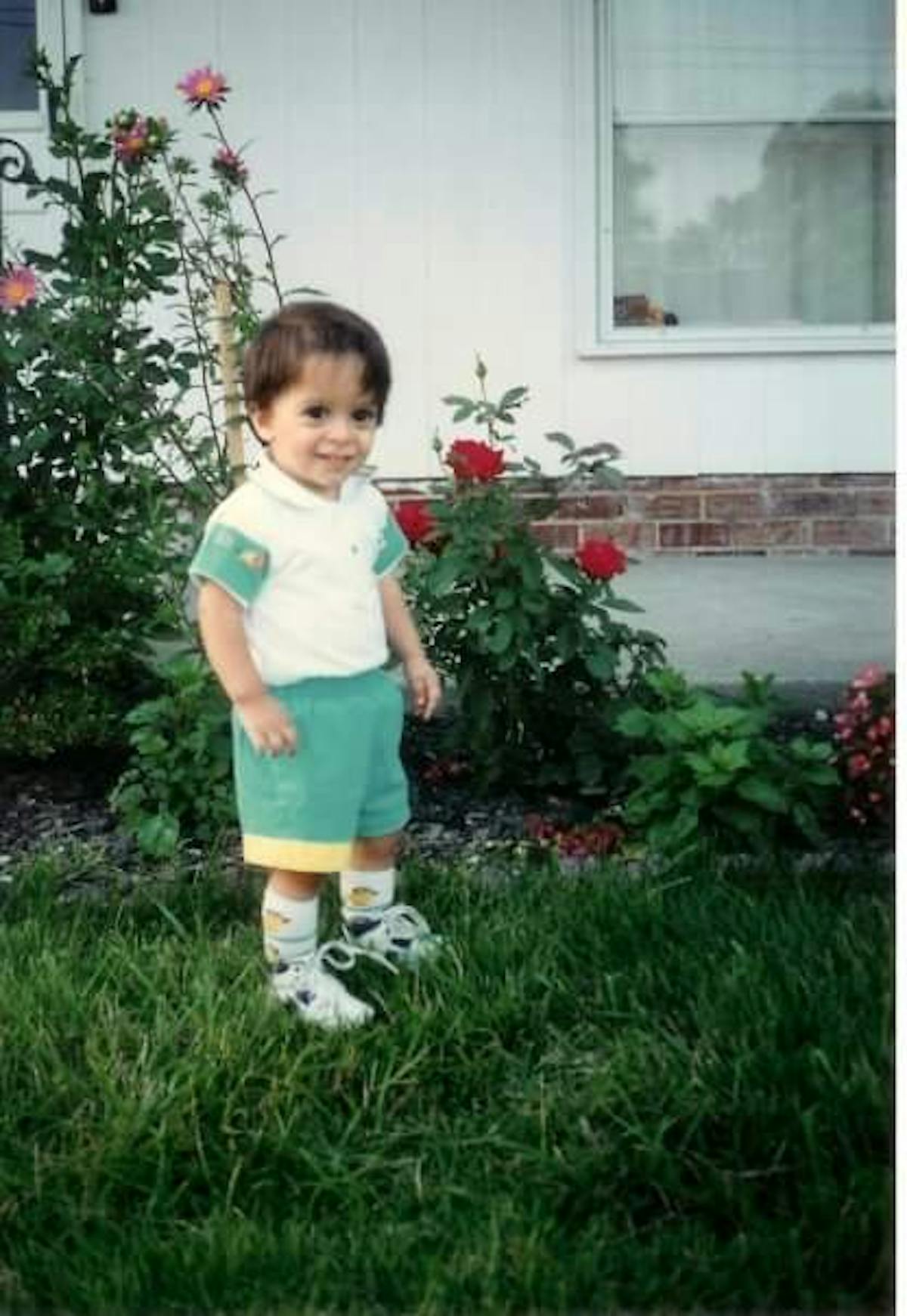 a little boy that is standing in the grass